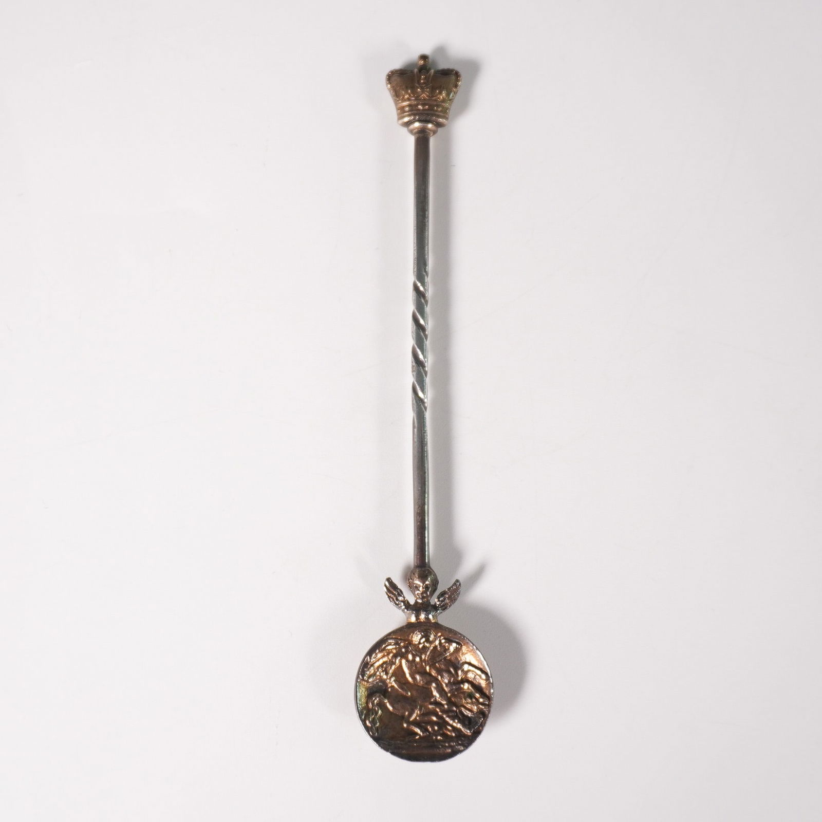 Metal Ornate Spoon with Crown Finial and Engraved London Medallion: This intricately designed metal spoon features a regal crowned finial atop a twisted stem, leading to a finely sculpted cherub figure just above the medallion. The round medallion is engraved with "Lo