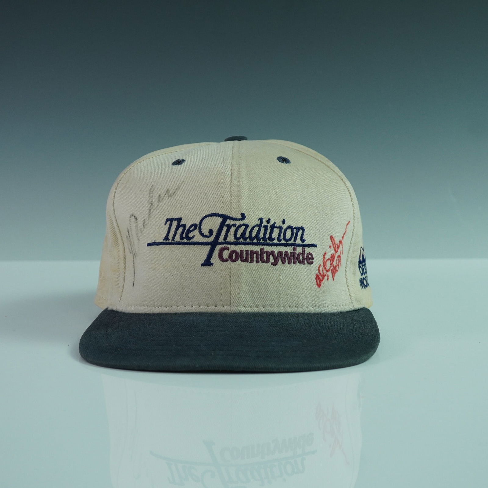 Countrywide Golf Cap Signed Al Geiberger and George Archer: Vintage The Tradition Countrywide golf cap featuring embroidered logos from Desert Mountain and Countrywide, signed by professional golfers Al Geiberger and George Archer. Geiberger's signature