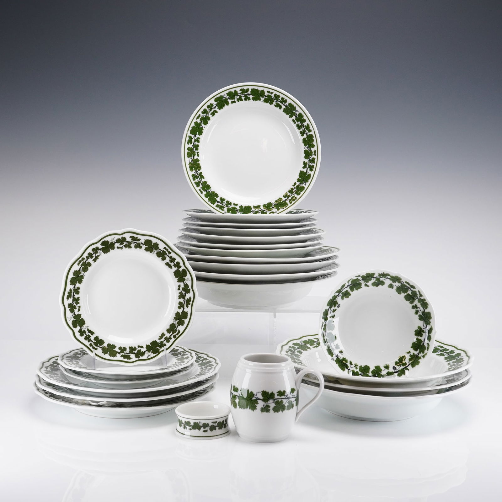 Collection of 23 Meissen Weinlaub Vine Leaf Porcelain Dinnerware Items: Meissen white glazed porcelain dinnerware decorated in the traditional 'Weinlaub' (Vine Leaf) pattern. The decoration features continuous green transfer-printed borders of grape leaves and vines. The