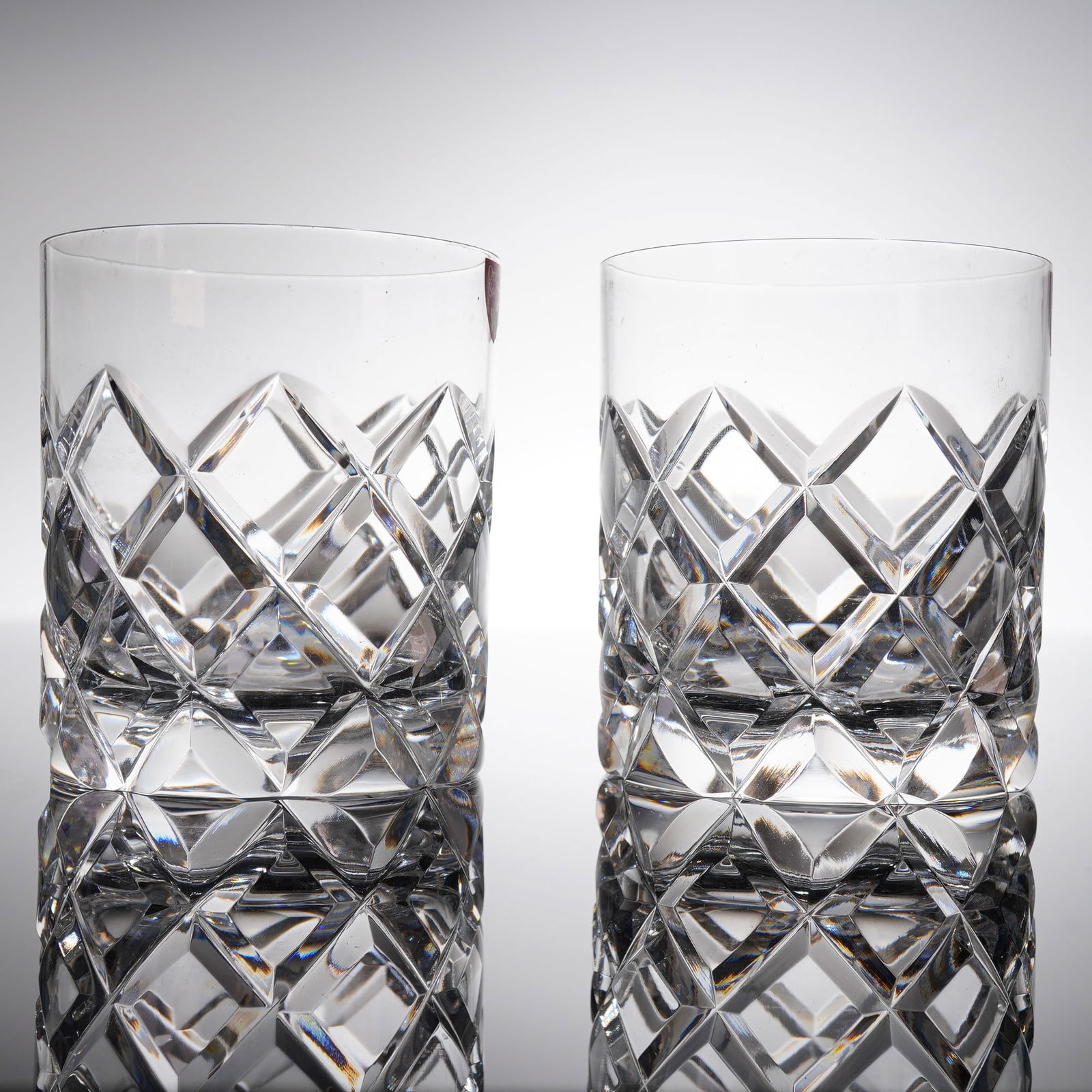 A Pair of Orrefors Sofiero Crystal Old Fashioned Glasses: A pair of heavy crystal old fashioned glasses in the Sofiero patern by Orrefors. The glasses feature deep, brilliant-cut decoration characterized by diamond cross-hatching covering the lower body and