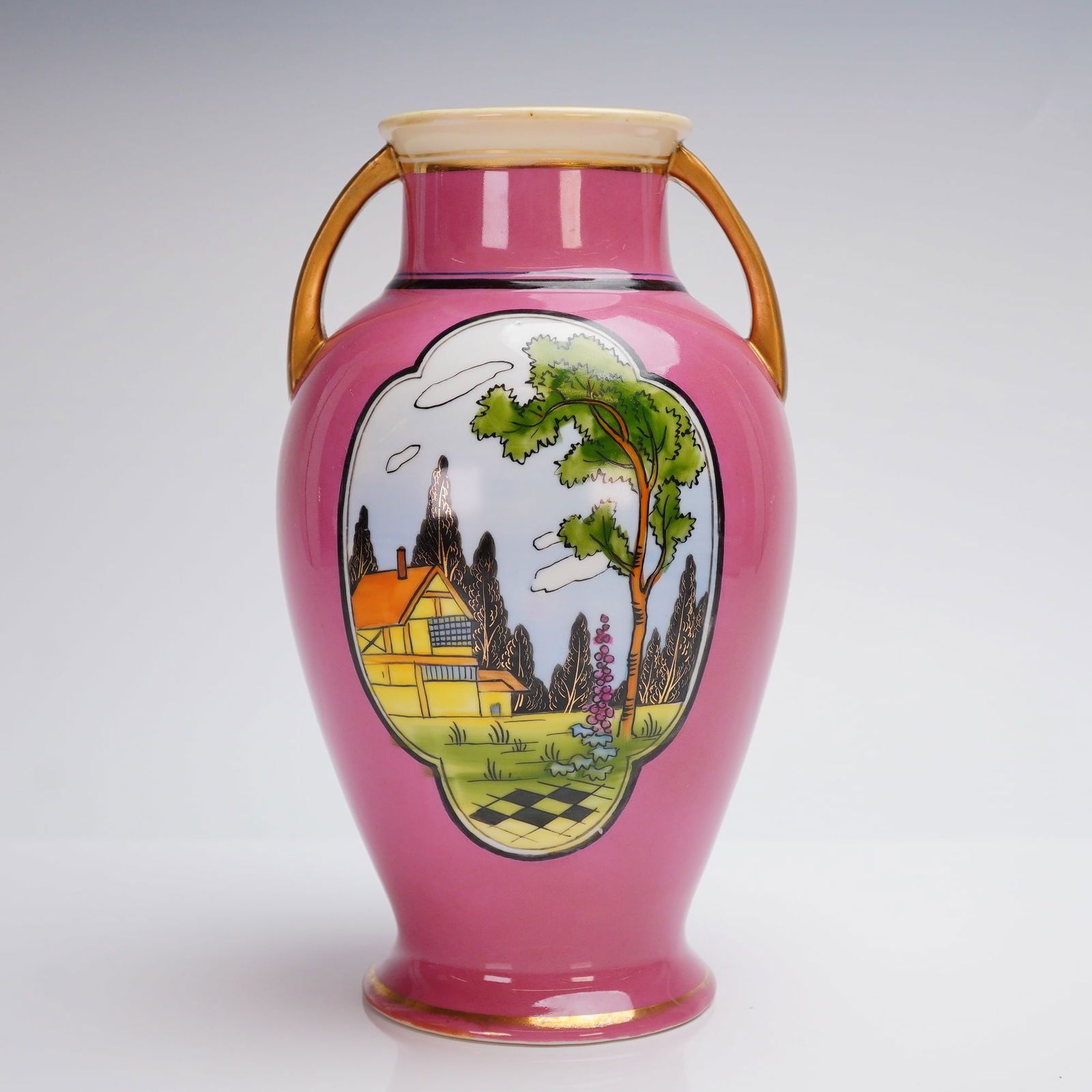 Noritake Double Handled Landscape Vase: The hand painted double handled vase of amphora form is consistent with Japanese export production from the 1920s to 1940s. The vase features a magenta/fuchsia ground glaze and is accented with gilt d