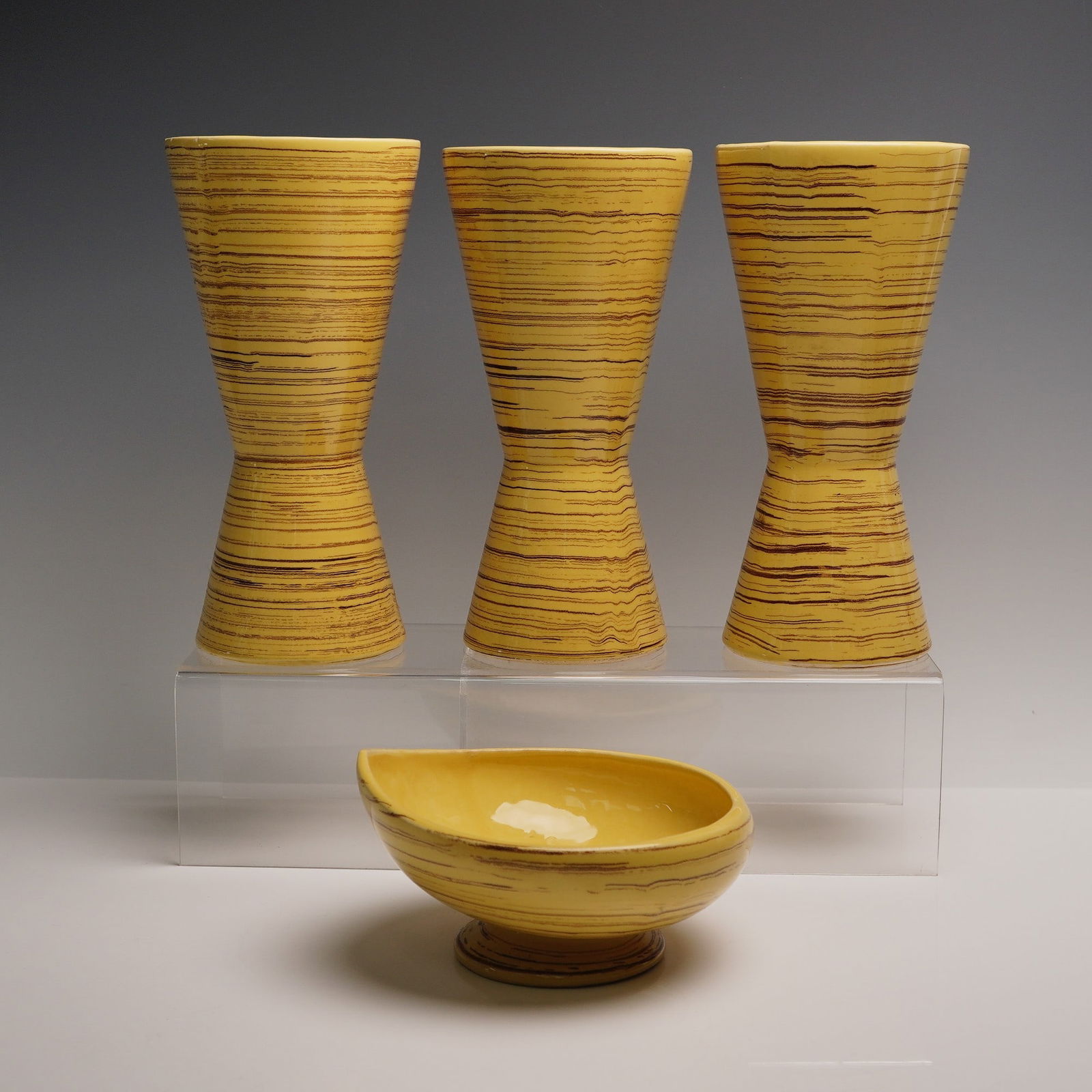 4pc McCoy Art Pottery Harmony Vases and Bowl: An eye catching quartet of vintage collectibles modeled in vibrant hues of yellow with brown stripes. Includes three tall harmony vases and a footed asymmetrical bowl. McCoy impressed backstamp. Vases