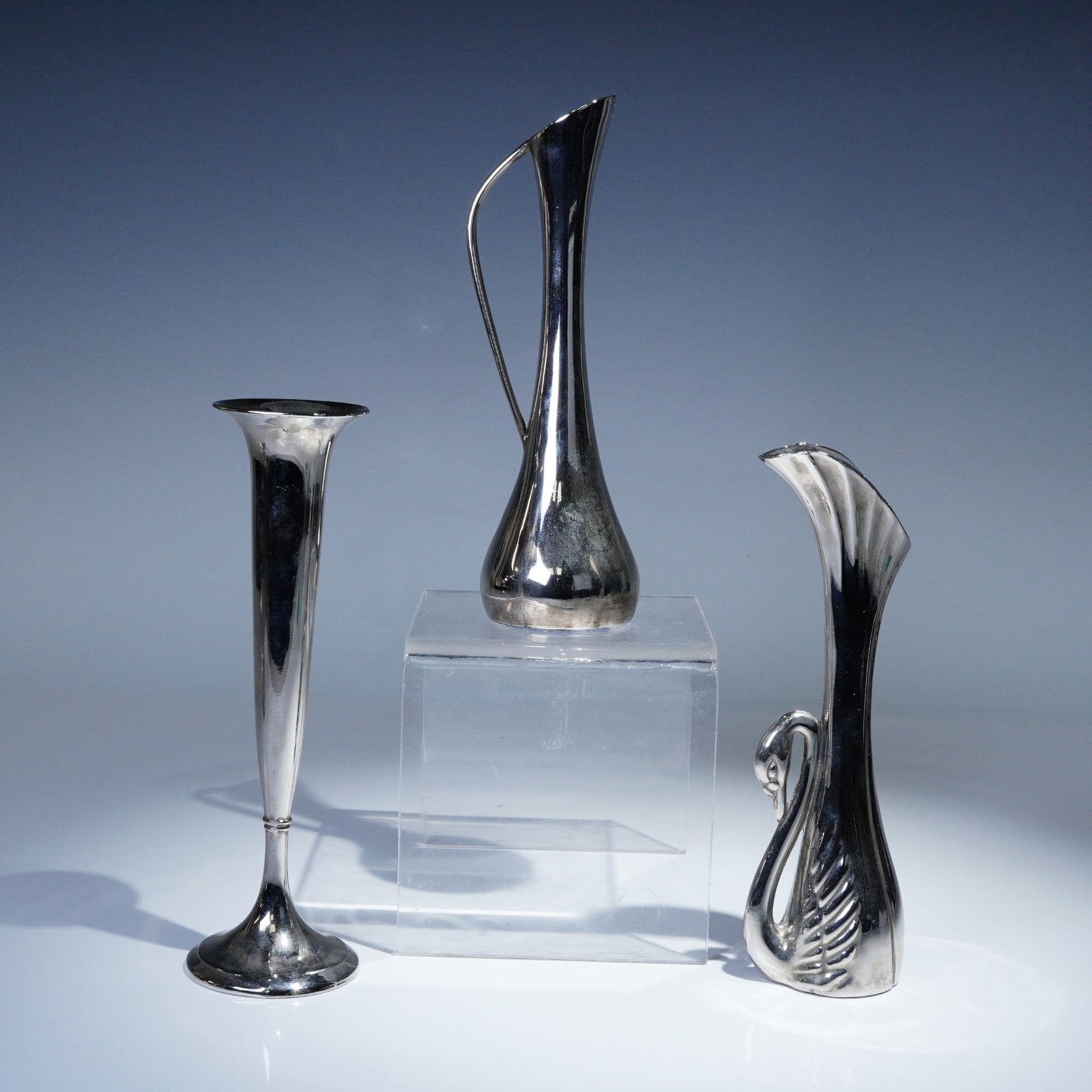 3pc International Silver Company Silverplated Bud Vases: Group of three elegant silverplated bud vases by International Silver Company. Includes one flared trumpet-form vase, one slender ewer-style vase with integrated handle, and one sculptural swan-handle