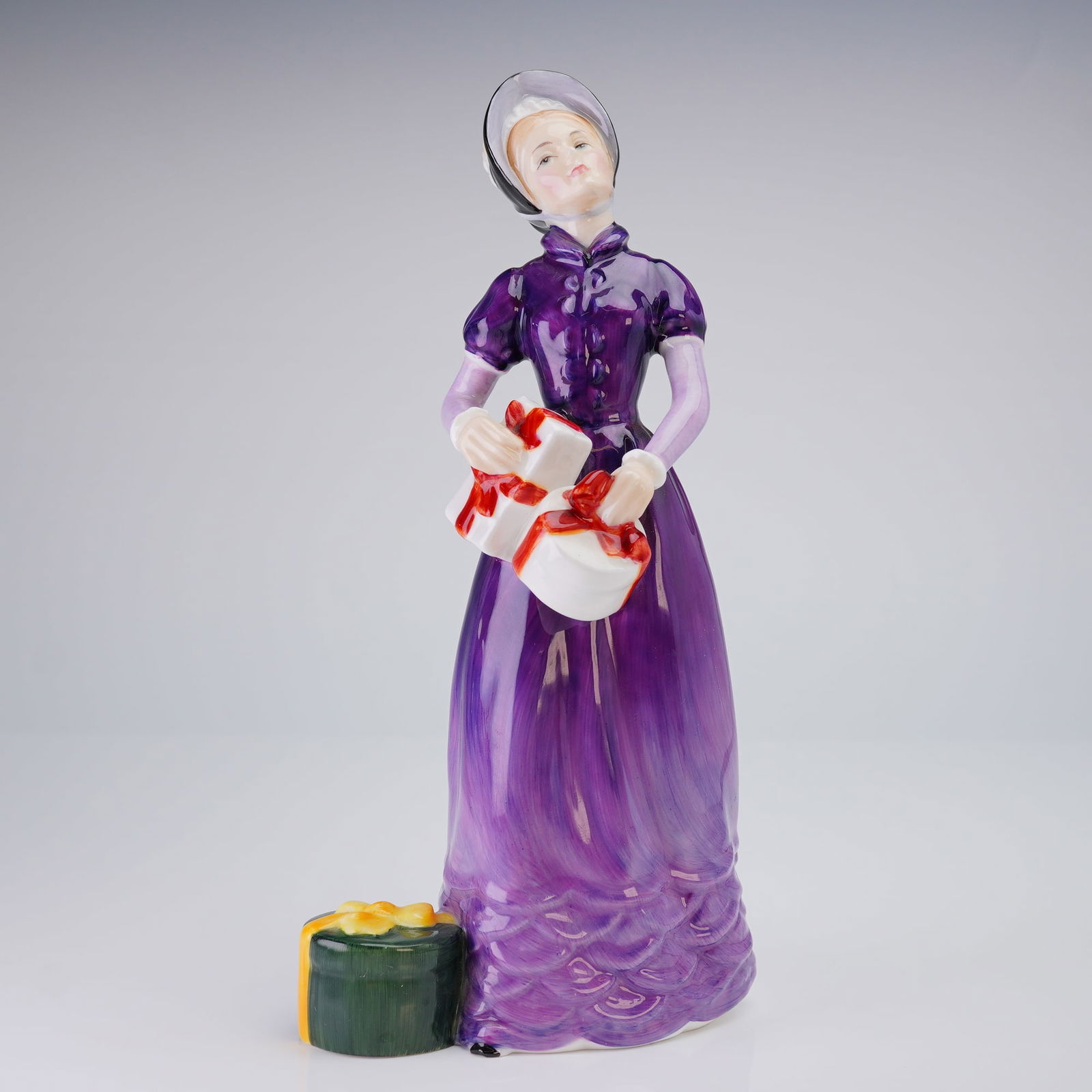 Royal Doulton Figurine, Good Day Sir HN2896: This Royal Doulton was modeled by William K. Harper and dates to 1985. The hand-decorated piece depicts a woman in a high-waisted purple dress and a bonnet, carrying white parcels tied with red ribbon
