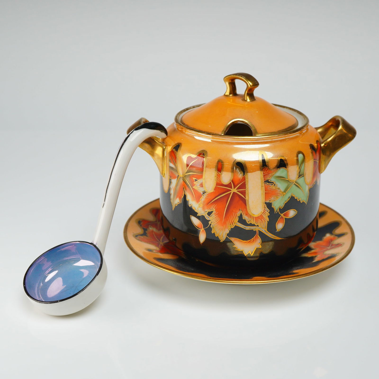 2pc Noritake Lusterware Lidded Sugar Bowl with Spoon and Plate Set: The vintage set comprises a lidded vessel, a coordinating underplate (plate), and a small serving ladle (spoon). The porcelain is decorated with a black ground overlaid by a highly lustrous, dripping