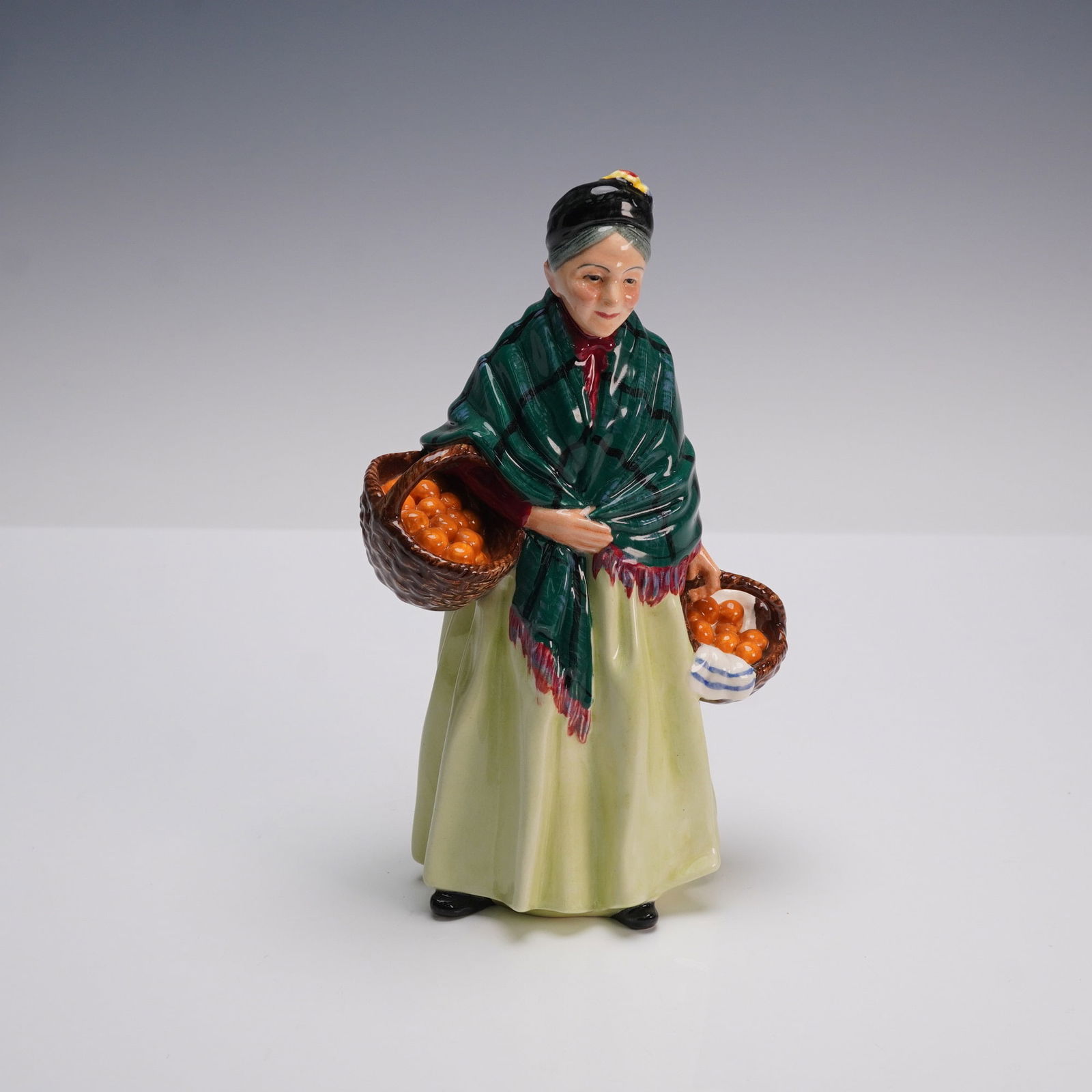 Royal Doulton Figurine, The Orange Lady HN1953: Royal Doulton figurine HN1953, titled The Orange Lady, designed by Leslie Harradine. Issued from 1940 to 1975 as part of the Street Vendor series, this hand painted glossy figure depicts an elderly wo