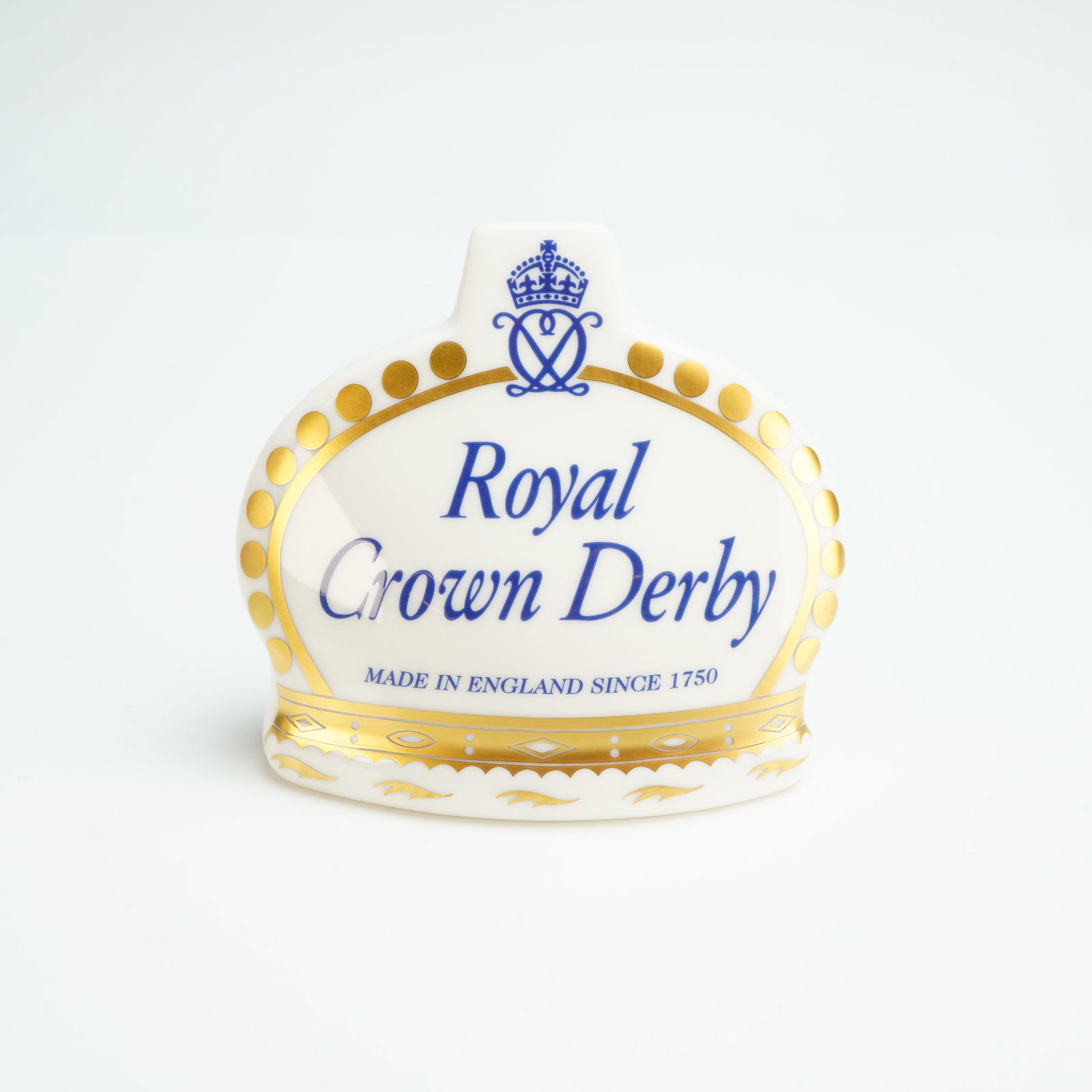 Royal Crown Derby Advertising Name Plaque: A Royal Crown Derby fine bone china Crown Namestand advertising name plaque with its original presentation box. The crown-shaped ceramic display sign features blue script lettering reading Royal Crown