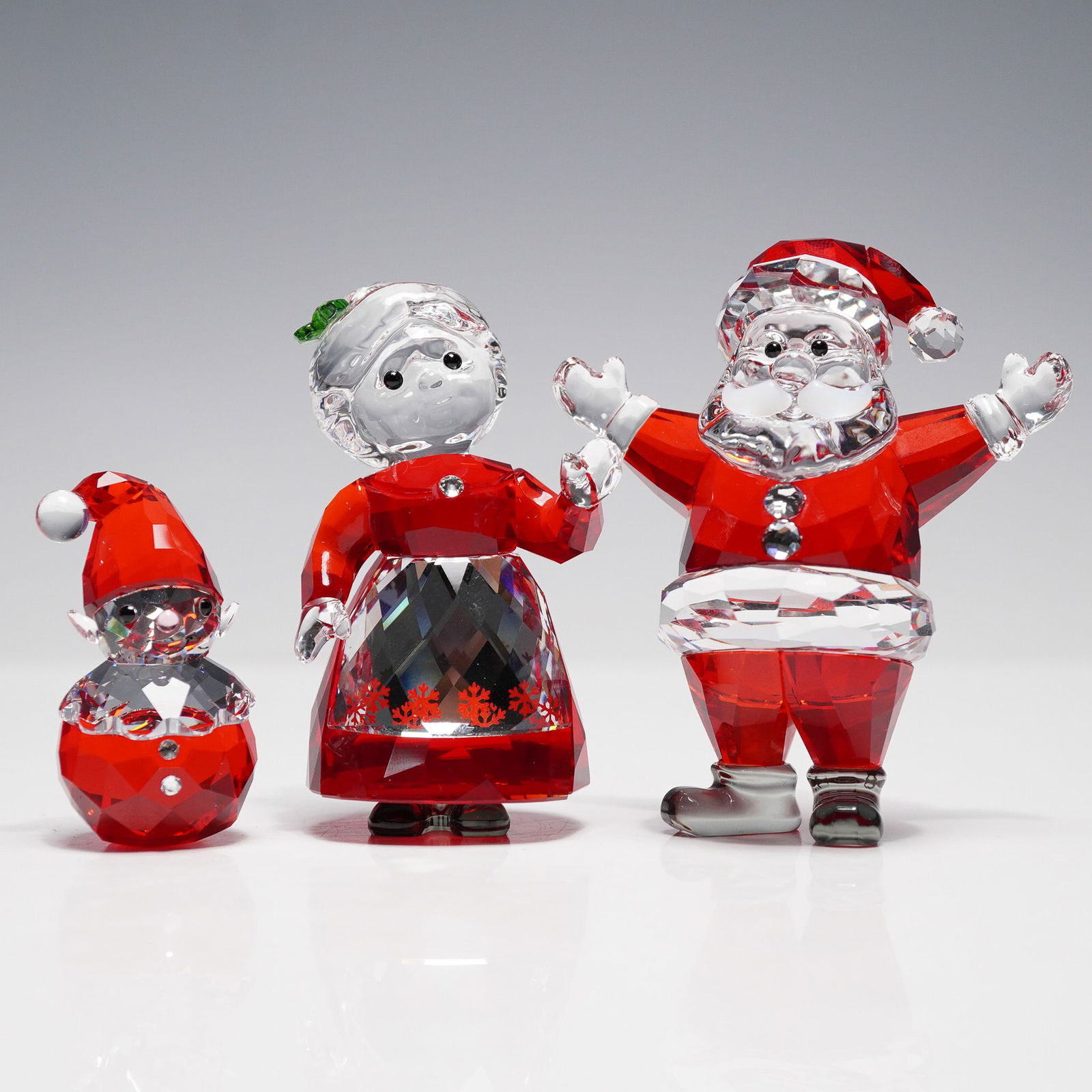 3pc Swarovski Crystal Christmas Figurines, Mr. & Mrs Santa & Elf: This festive crystal trio includes, Santa Claus, Mrs. Claus, and Rocking Elf. Each figure is beautifully crafted in clear and red crystal, with white or green crystal accents. Swarovski etched backsta