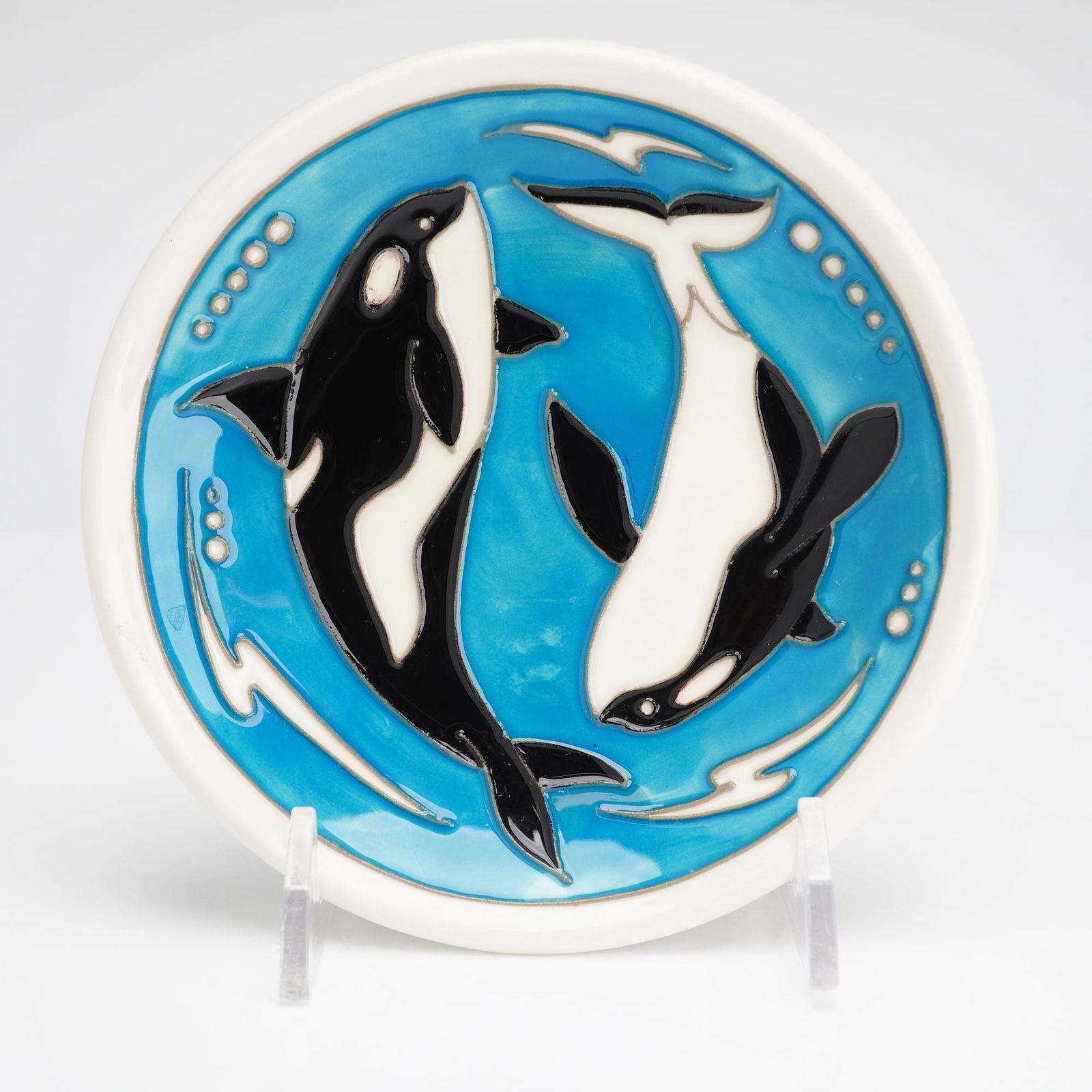 Moorcroft Orca Pattern Plate: This Moorcroft glazed ceramic plate features a design of two orcas swimming in a circular formation. The decoration is set against a turquoise background and includes stylized bubbles and white splash