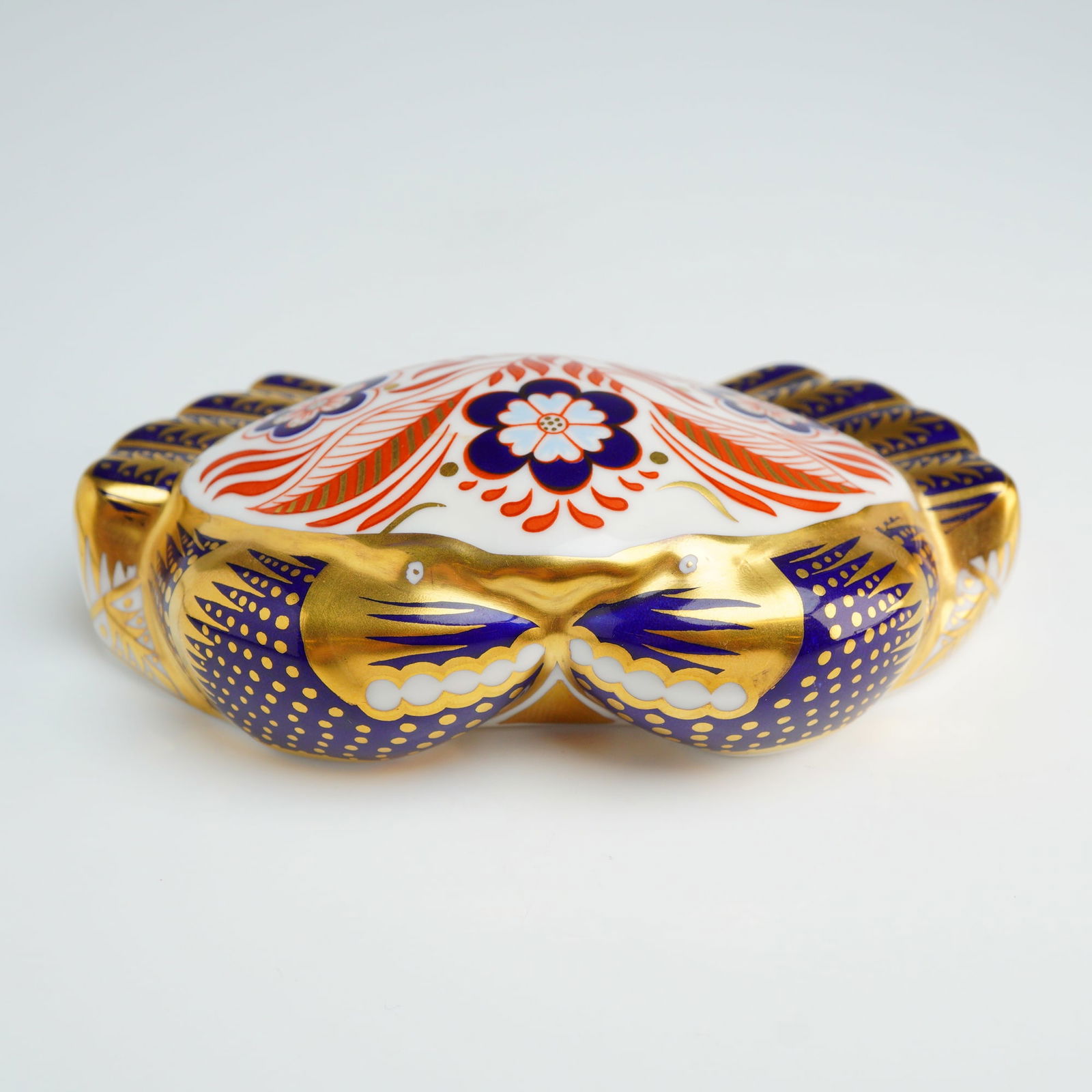Royal Crown Derby Imari Crab Paperweight: A Royal Crown Derby fine bone china paperweight modeled in the form of a crab and decorated in the traditional Imari palette. The stylized crustacean features floral and foliate motifs in cobalt blue,