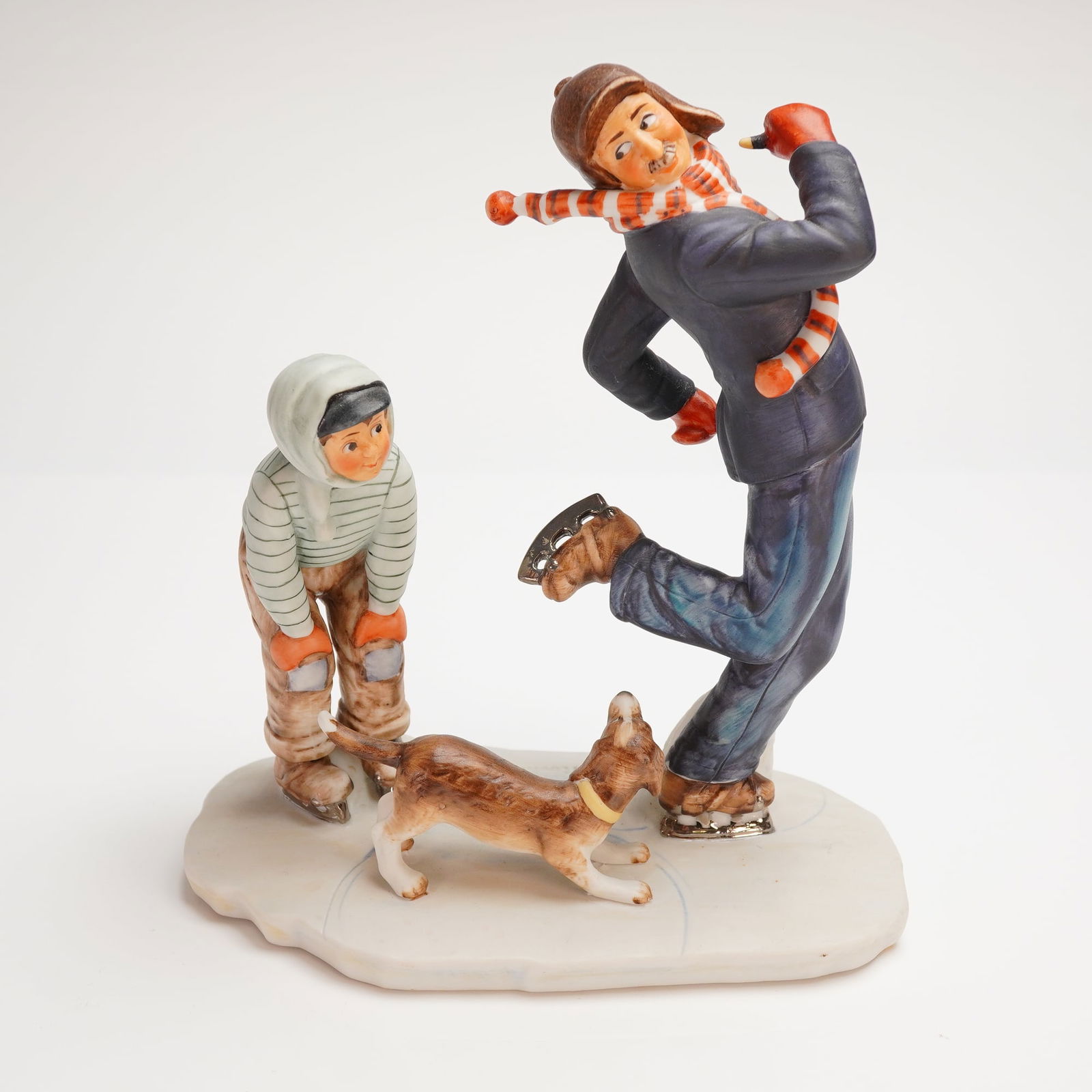 Gorham Norman Rockwell Winter Gay Blades Porcelain Figurine Group: A single polychrome glazed porcelain figurine group manufactured by Gorham, inspired by Norman Rockwells 1948 Four Seasons Illustration titled "Winter - Gay Blades." The composition depicts a dynamic