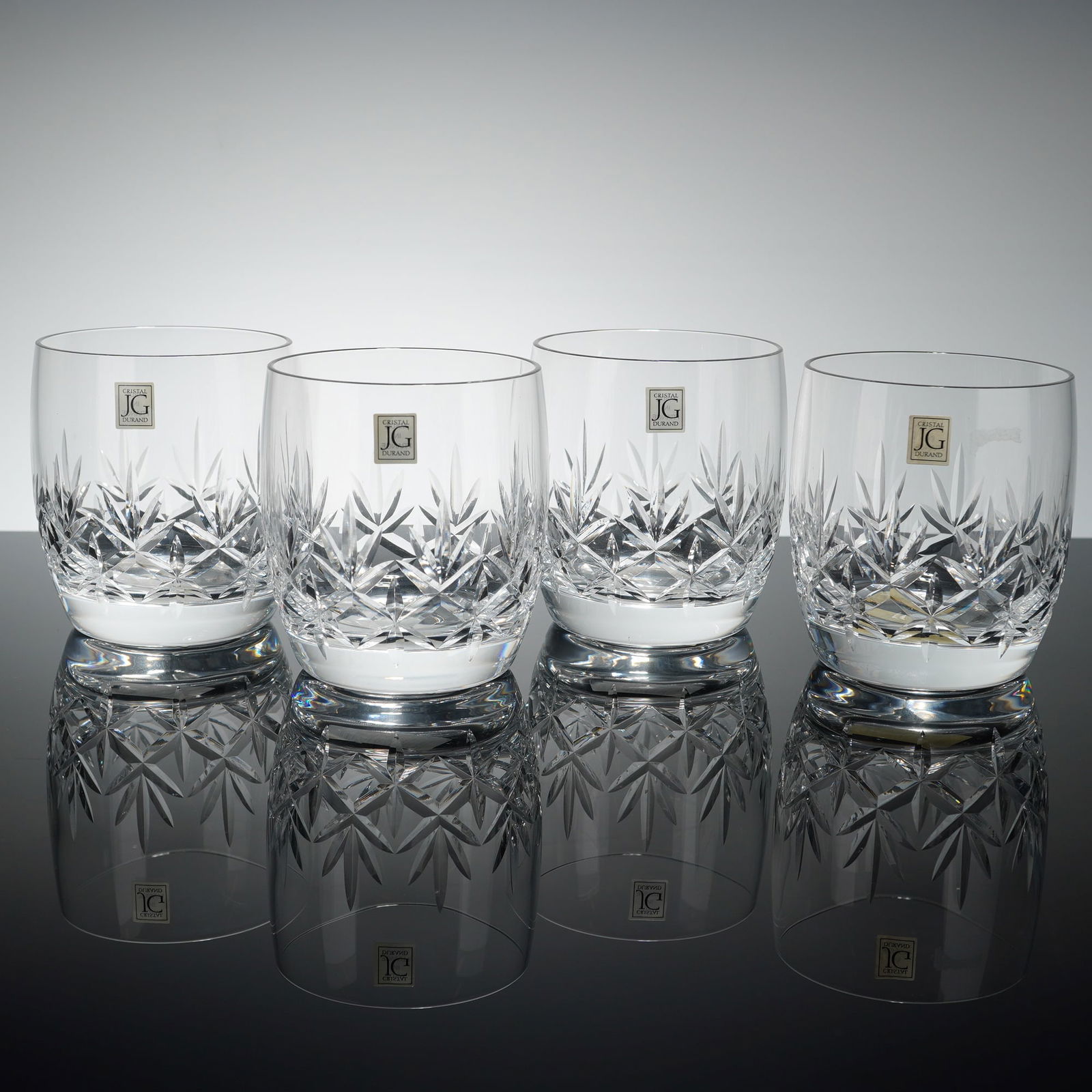 Set of 4 J.G. Durand France Crystal Glass Tumblers, Orion: These double old fashioned (DOF) vessels are crafted from clear crystal and feature a deep-cut geometric starburst motif encircling the lower body. The glasses are designed with a solid, weighted base