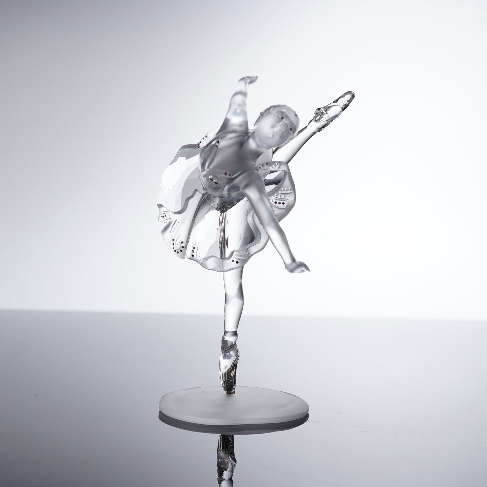 Swarovski Crystal Ballerina Figurine: A Swarovski Crystal Figurine, Ballerina model (236715), crafted from clear and frosted crystal, depicting a dancer performing, balanced on one foot in a pointe shoe. The ballerina stands on a frosted