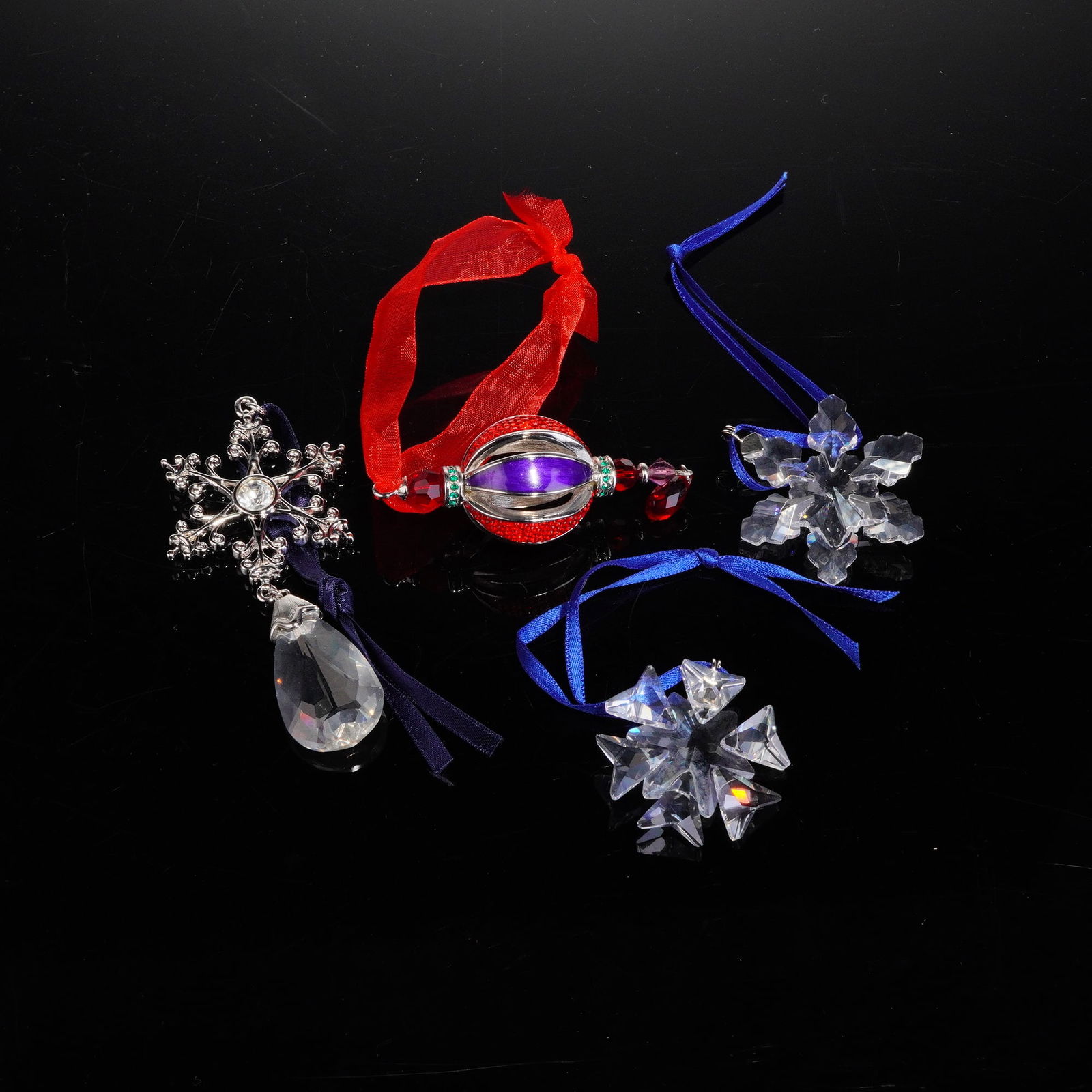 4pc Swarovski Crystal Ornaments: The collection includes four distinct pieces identified by their model names and numbers: the Teardrop ornament (1299915), the Little Snowflake ornament (0934706), the Little Star ornament (0884869),