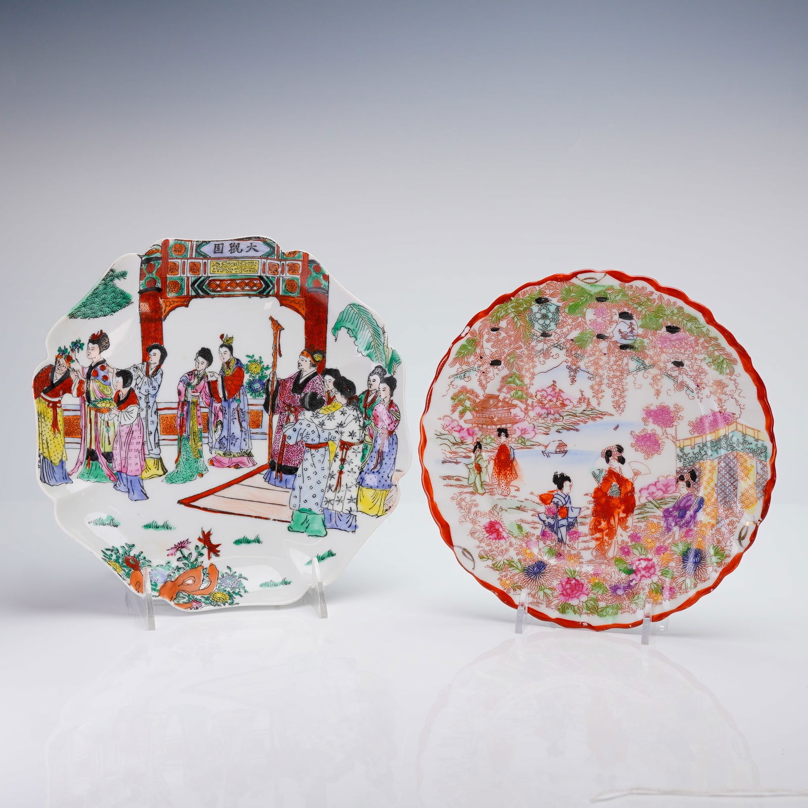 2pc Decorative Enameled Porcelain Plates, Made in Japan and Macau: A duo of decorative ceramic plates, both featuring polychrome enamel decoration. The first is a multi-scalloped octagonal plate decorated with a large group of figures beneath a ceremonial gate inscri