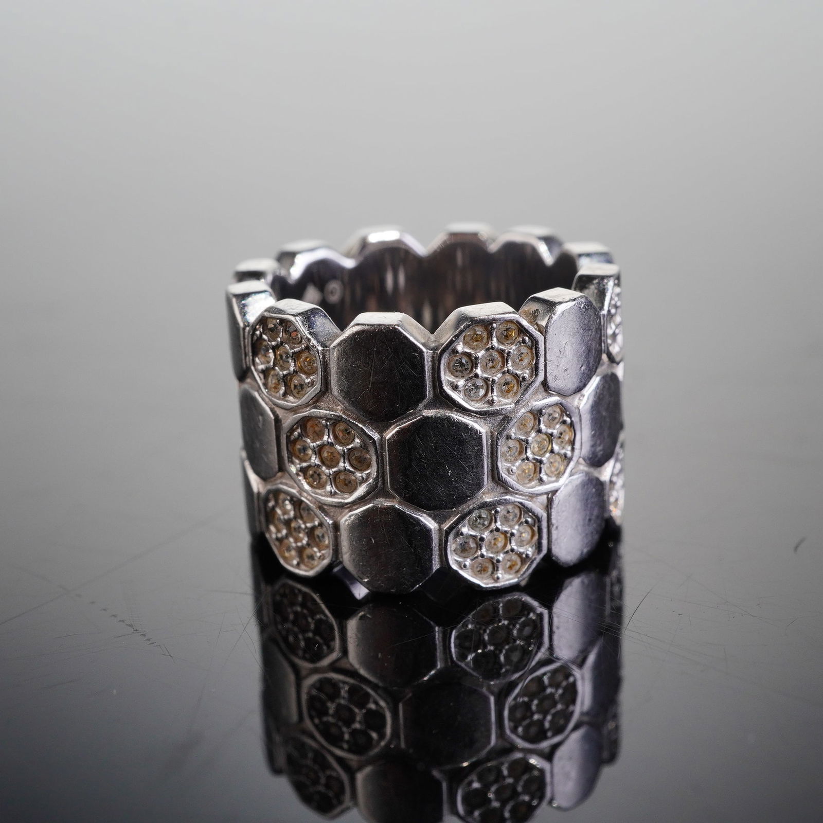 Swarovski Crystal Lake of Shimmer Rhodium Plated Ring: The wide band ring features a contemporary design composed of three continuous rows of tessellated hexagonal cells. Alternating hexagonal cells are pave set with numerous small round crystals, exhibit