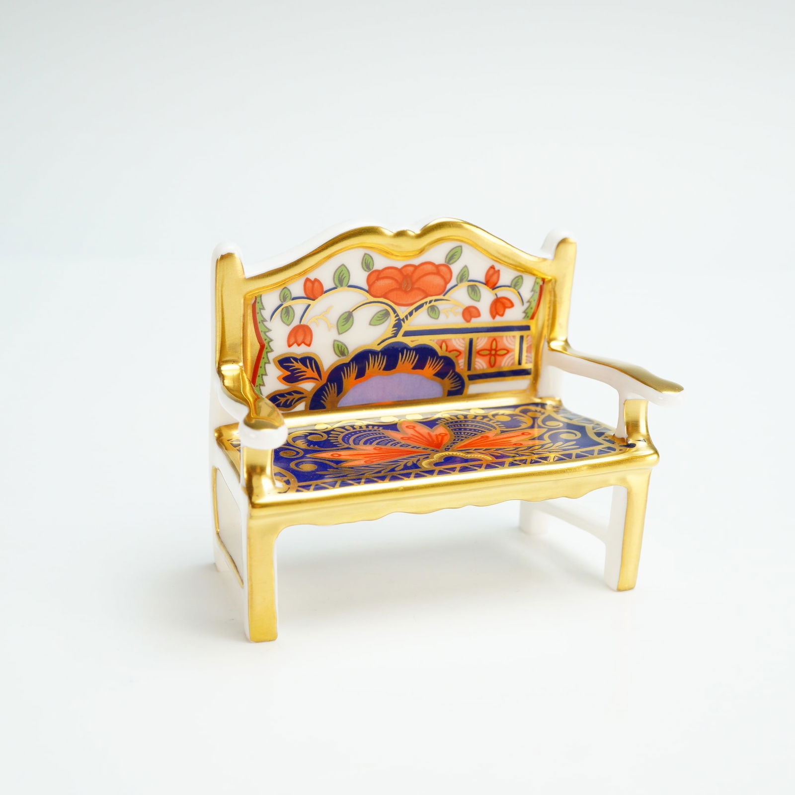 Royal Crown Derby Miniature Figurine, Garden Bench: A Royal Crown Derby miniature bone china garden bench, decorated in a traditional Imari pattern. This novelty garden bench paperweight features a color palette of cobalt blue and iron-red with hand-ap