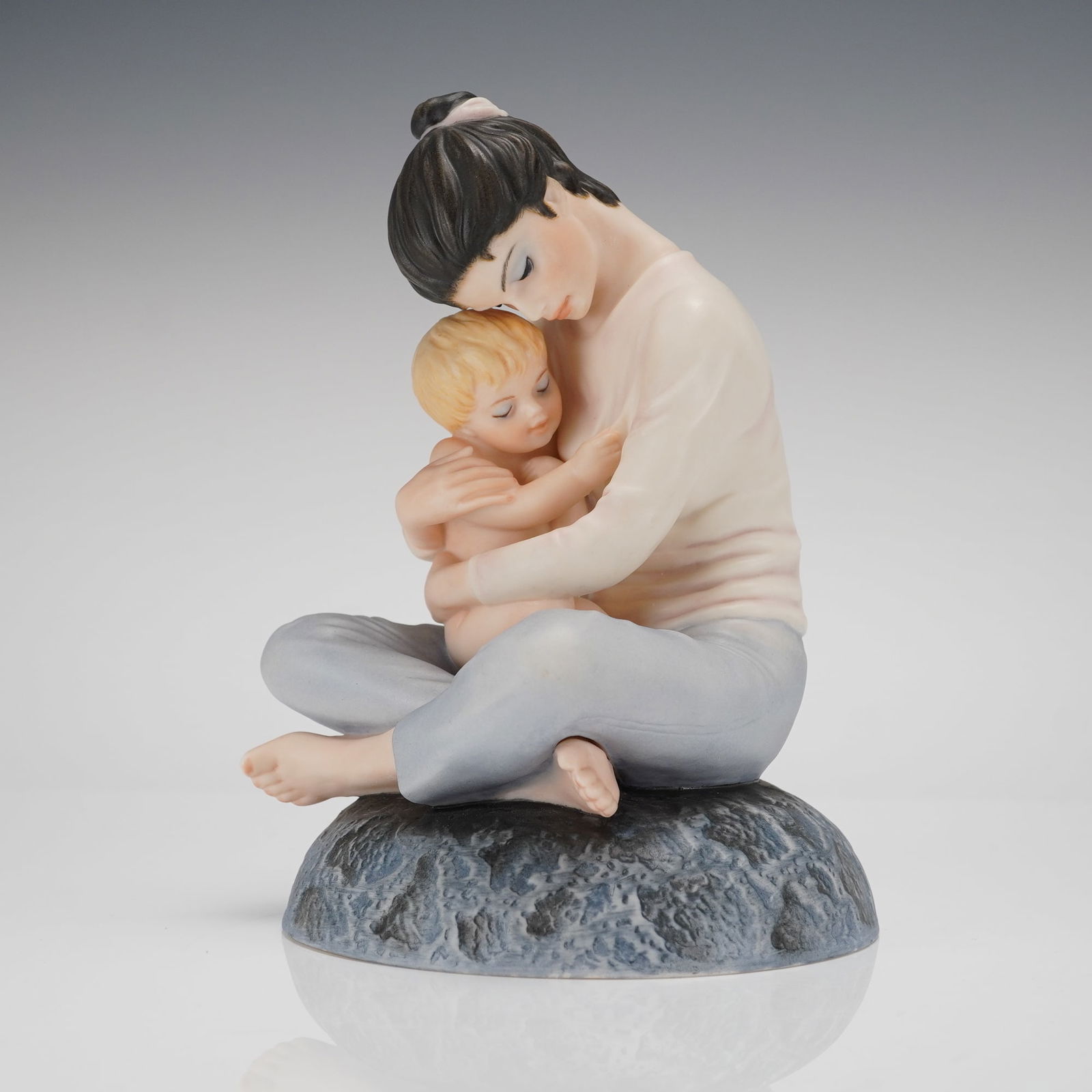 Goebel Irene Spencer Ltd Ed Fig. Yesterday, Today & Tomorrow 1979: A single porcelain figurine designed by Irene Spencer for Goebel U.S.A. 1979, titled Yesterday, Today & Tomorrow. The piece depicts a seated mother embracing her young child, rendered in a contemp