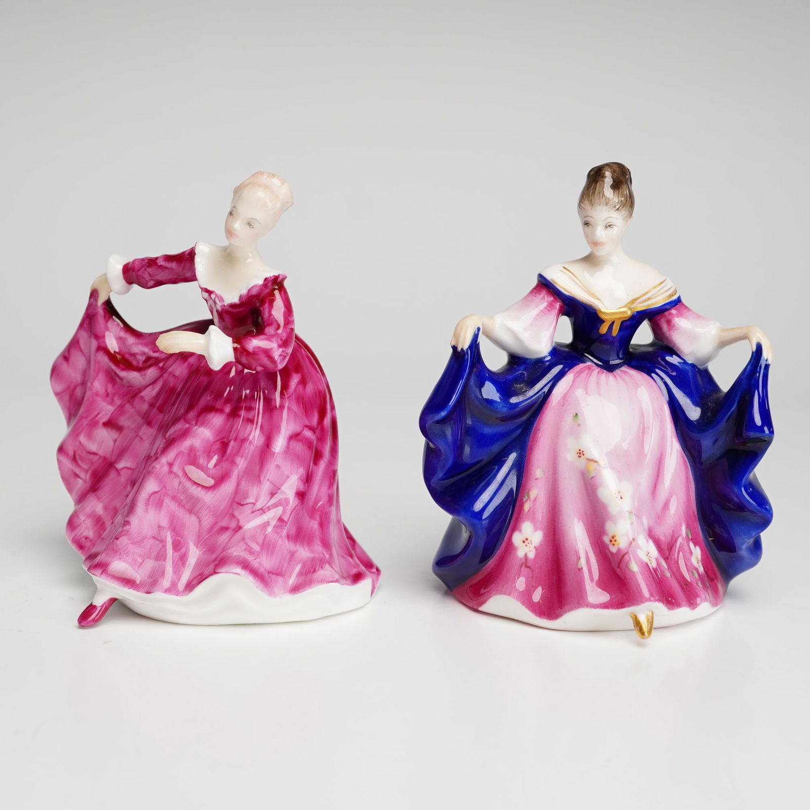 2pc Royal Doulton Mini Figurines, Kristy HN3213 and Sara HN3249: Both designed by Peggy Davies. Kristy is modeled in a flowing marbled pink gown with white bodice, while Sara wears a vibrant cobalt blue and pink dress accented with delicate floral decoration and gi
