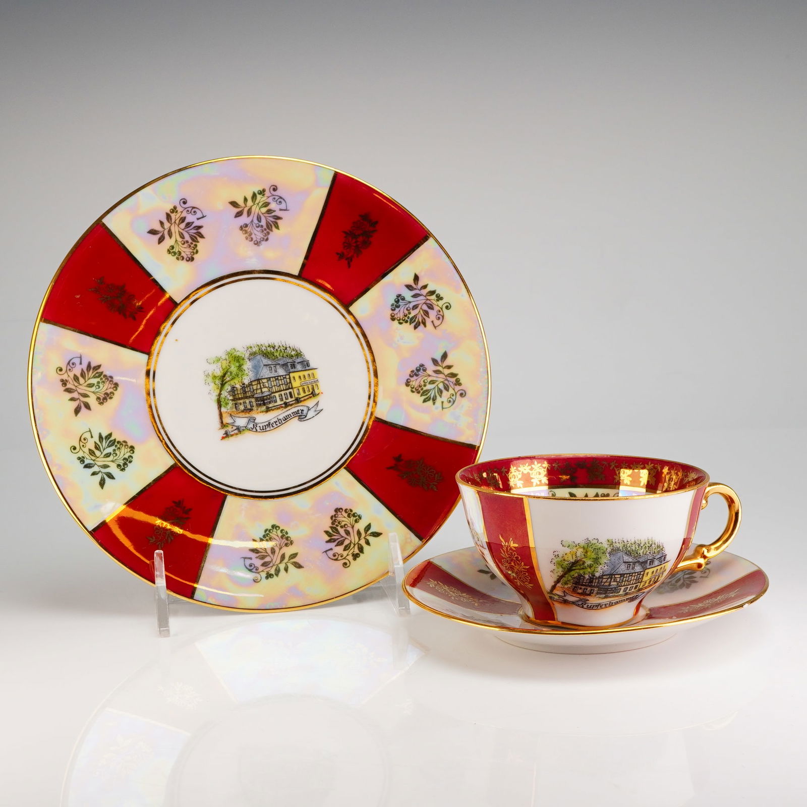 Gerold Porzellan Bavaria Trio Tea Set, Kupferhammer: This is a 3pc set, Cup, Saucer & Dessert Plate, has a white porcelain body decorated with alternating panels of deep red enamel and an iridescent luster glaze. Extensive gilt detailing is present, inc