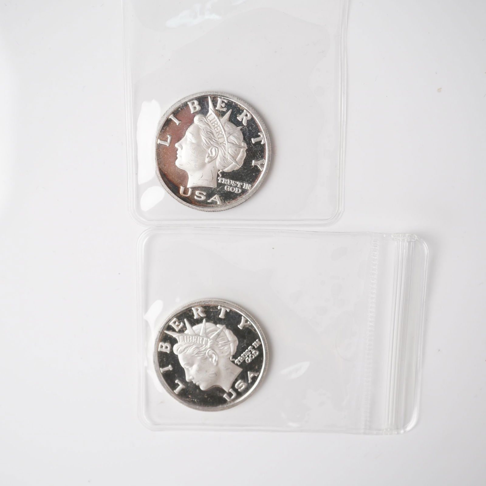 2pc 2003 1/2 Troy Ounce Five Dollar Silver Rounds: Two Liberty Dollar silver rounds, each struck in .999 fine silver with a nominal value of five dollars. The obverse depicts a classical bust of Liberty facing left, adorned with a diadem inscribed