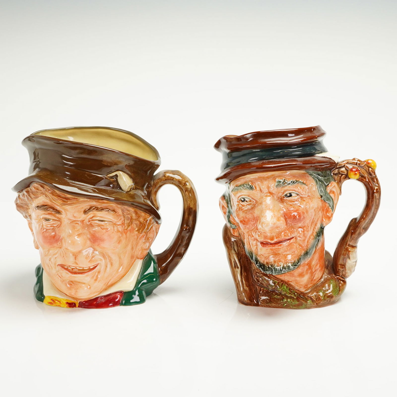 2pc Royal Doulton Large Character Jugs, Paddy and Johnny Appleseed: A pair of Royal Doulton glazed ceramic character jugs, identified as Paddy (D5753) and Johnny Appleseed (D6372). Both jugs feature high-gloss polychrome decoration depicting caricatured heads of men w