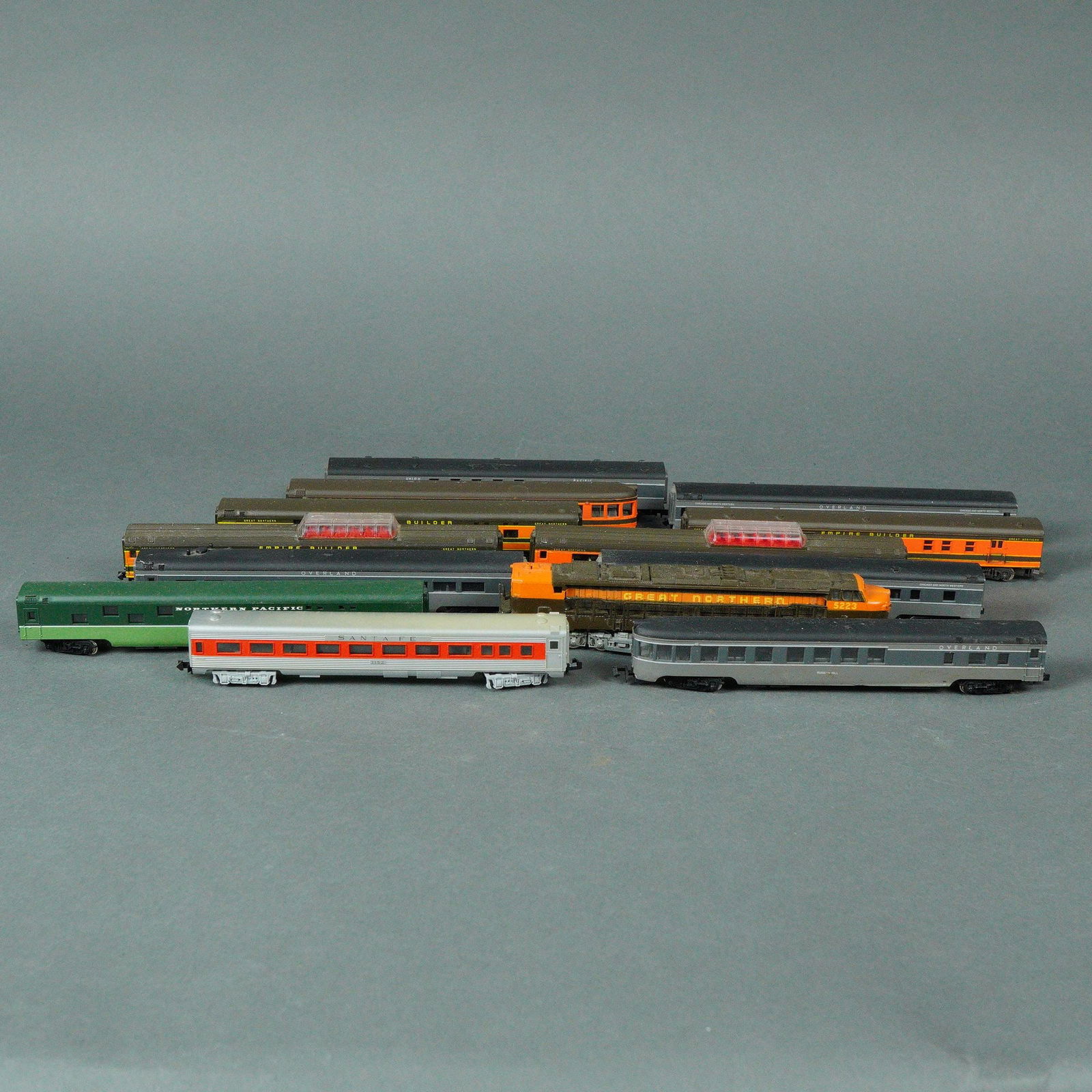 Assortment Sekisui Con-Cor N Scale Model Railroad Cars and Locomotive: A collection of thirteen individual N scale model railroad items, comprising one locomotive and twelve passenger cars, predominantly constructed of plastic. The items were manufactured by Sekisui Con-