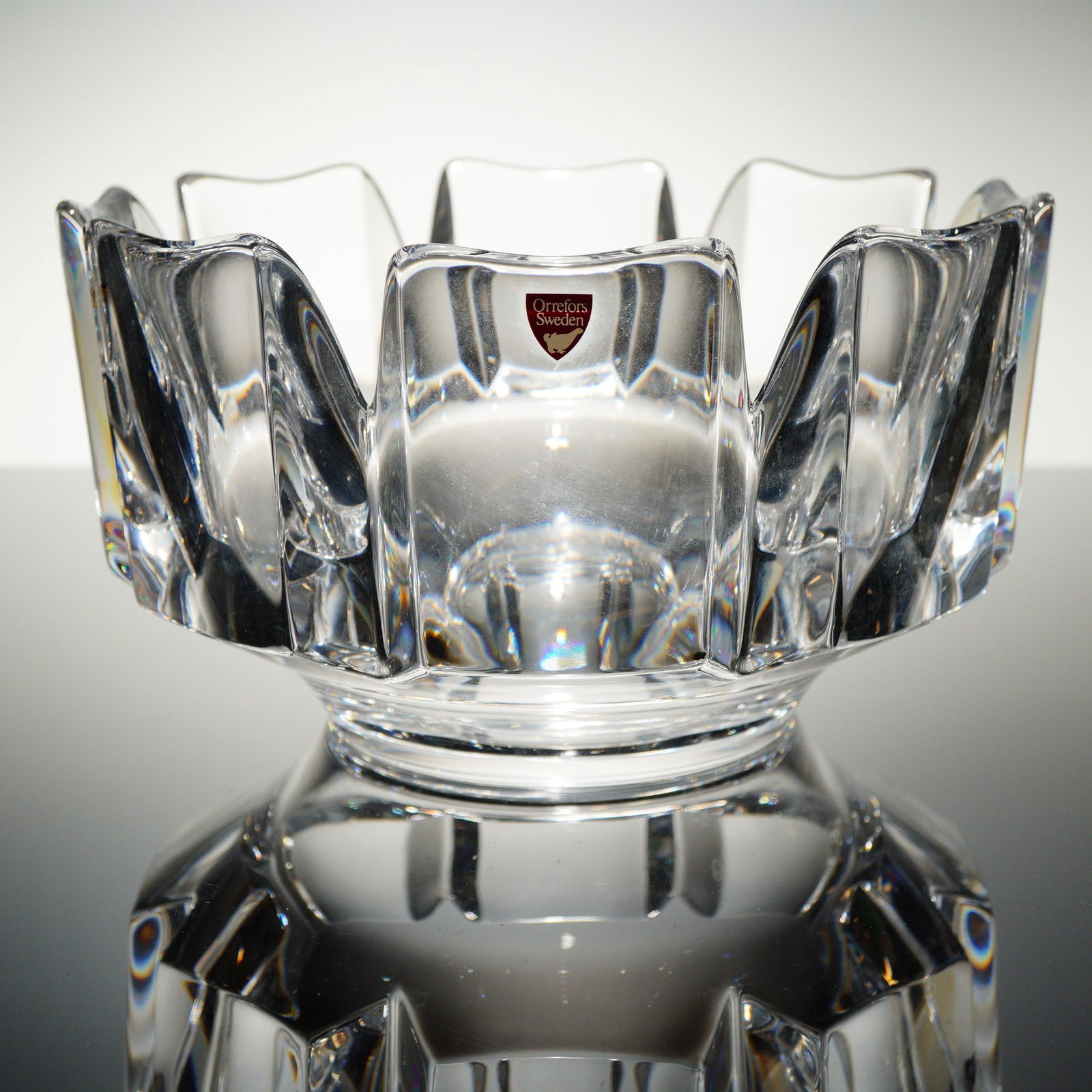 Orrefors Corona Crystal Bowl by Lars Hellsten: A single Orrefors crystal bowl in the "Corona" patern, designed by Lars Hellsten. The bowl is constructed of clear, heavy glass with a deep circular well and a substantial base. The rim is characteriz