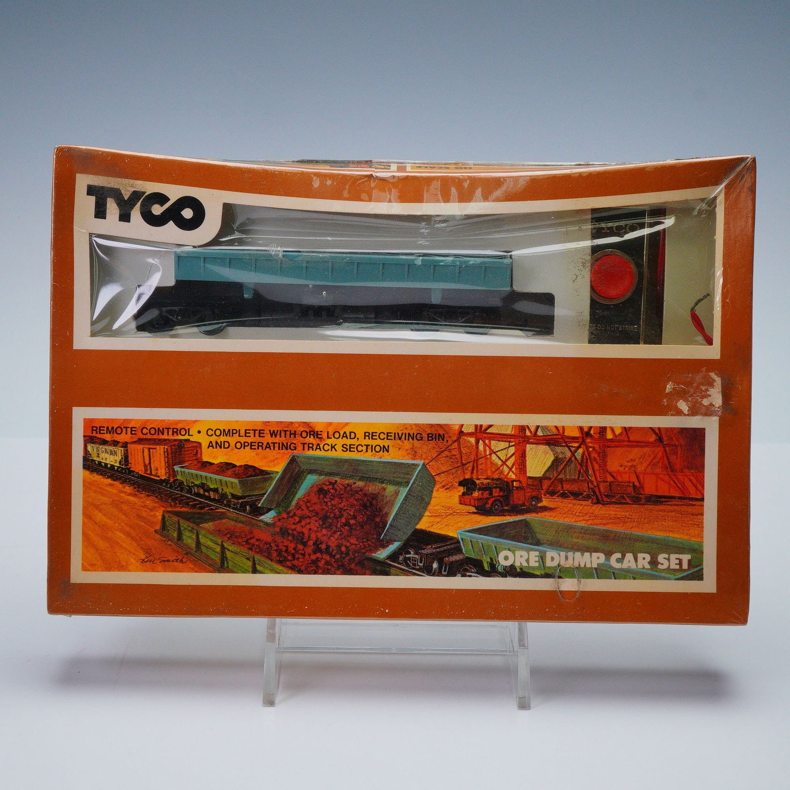 Tyco HO Scale Ore Dump Car Set: Vintage Tyco Ore Dump Car Set, complete with remote control, ore load, receiving bin, and operating track section, all housed in its original orange and white retail box. The front of the box features