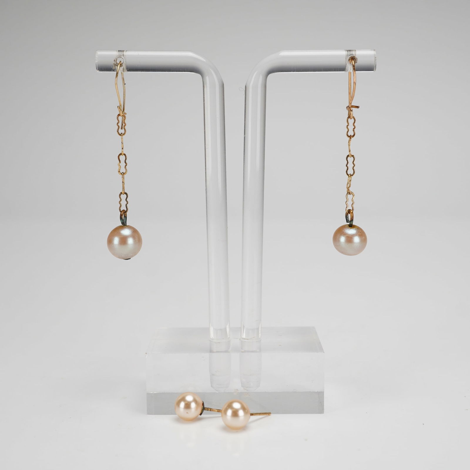 2 Pairs of Pearl Gold-Toned Stud and Drop Earrings: Presented are two pairs of earrings, one featuring a gold-toned link chain finished with a pearl at the end, and small round pearl studs with gold-toned posts. Measurement is for largest item. Dimensi
