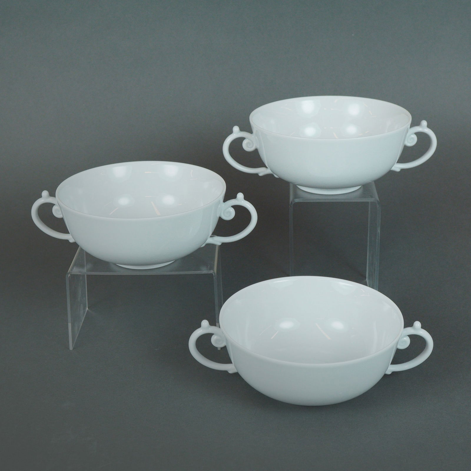 3pc L'Objet Double Handle Porcelain Soup Bowls, Aegean White: A trio of three L'Objet Aegean double handle soup bowls featuring white porcelain construction and marked with the L'Objet backstamp. Dimensions: 7.75"L x 6.00"W x 2.50"H Weight: 2.11 lb