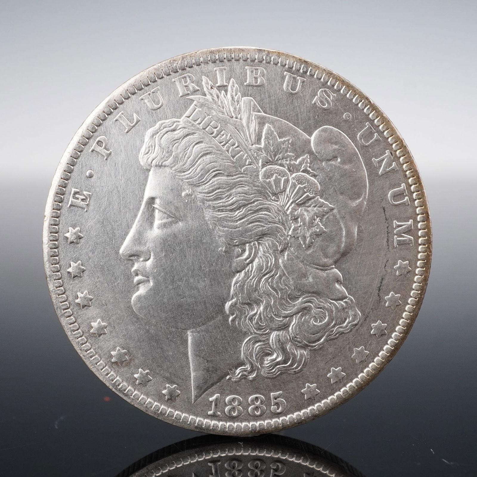 1885-O Morgan Silver Dollar: Minted in 1885 at the New Orleans Mint, this Morgan Silver Dollar is composed of 90% silver. he obverse features George T. Morgan's neoclassical depiction of Liberty wearing a Phrygian cap adorned wit