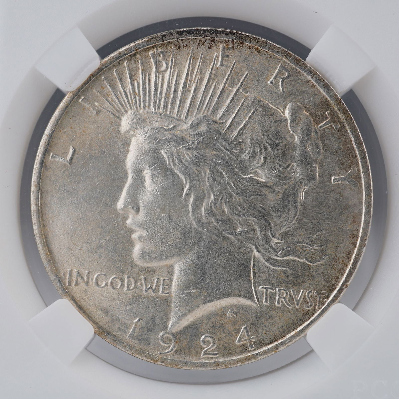 1924 Peace Silver Dollar: A 1924 Peace Silver Dollar designed by Anthony de Francisci. The obverse portrays Liberty in classical profile, adorned with a radiant crown symbolizing enlightenment and freedom, accompanied by the i