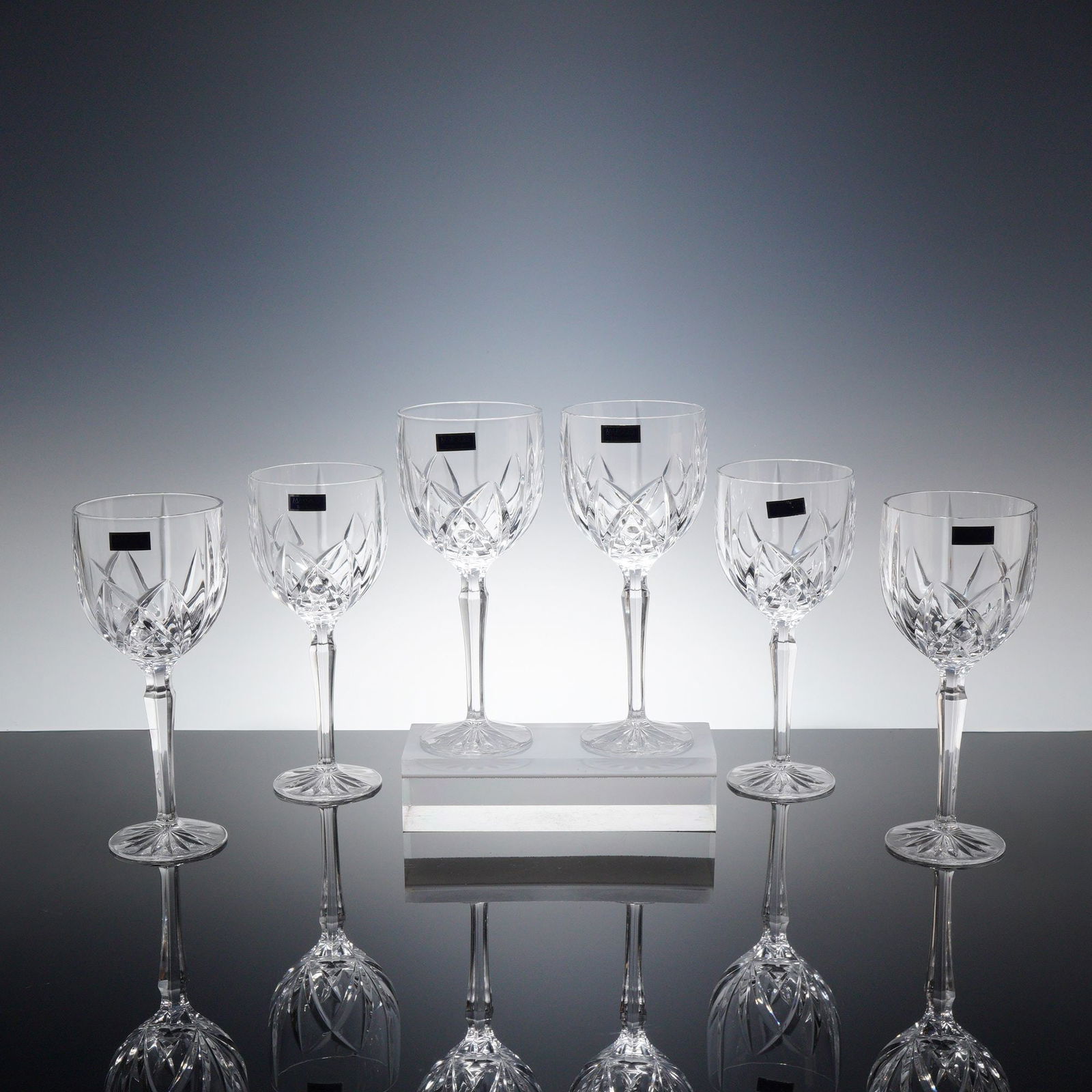 Set of 6 Marquis by Waterford Crystal Wine Glasses, Brookside: Each glass is crafted from clear lead crystal and features a contemporary design with vertical and crisscross wedge cuts around the base of the bowl. The bowls are supported by long, faceted stems. Th