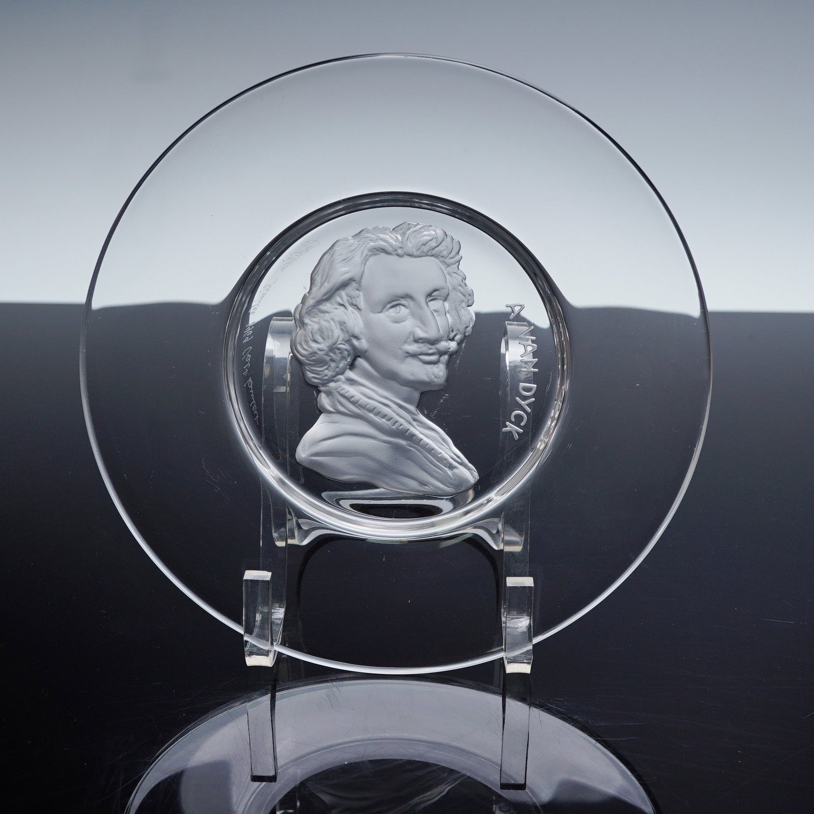 Val St. Lambert Crystal Limited Edition Depicting A. Van Dyck Plate: A fine crystal commemorative plate by Val Saint Lambert featuring a raised profile of Sir Anthony Van Dyck. This limited edition piece, dated 1969 and signed in script along the rim, presents a froste