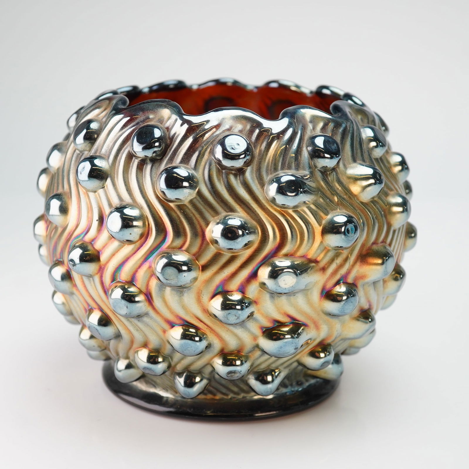 Millersburg Amethyst Swirled Hobnail Carnival Glass Bowl: A Millersburg amethyst carnival glass rose bowl in the Swirled Hobnail pattern, produced circa 1910. The vessel features a globular form with a crimped and ruffled rim. The exterior decoration