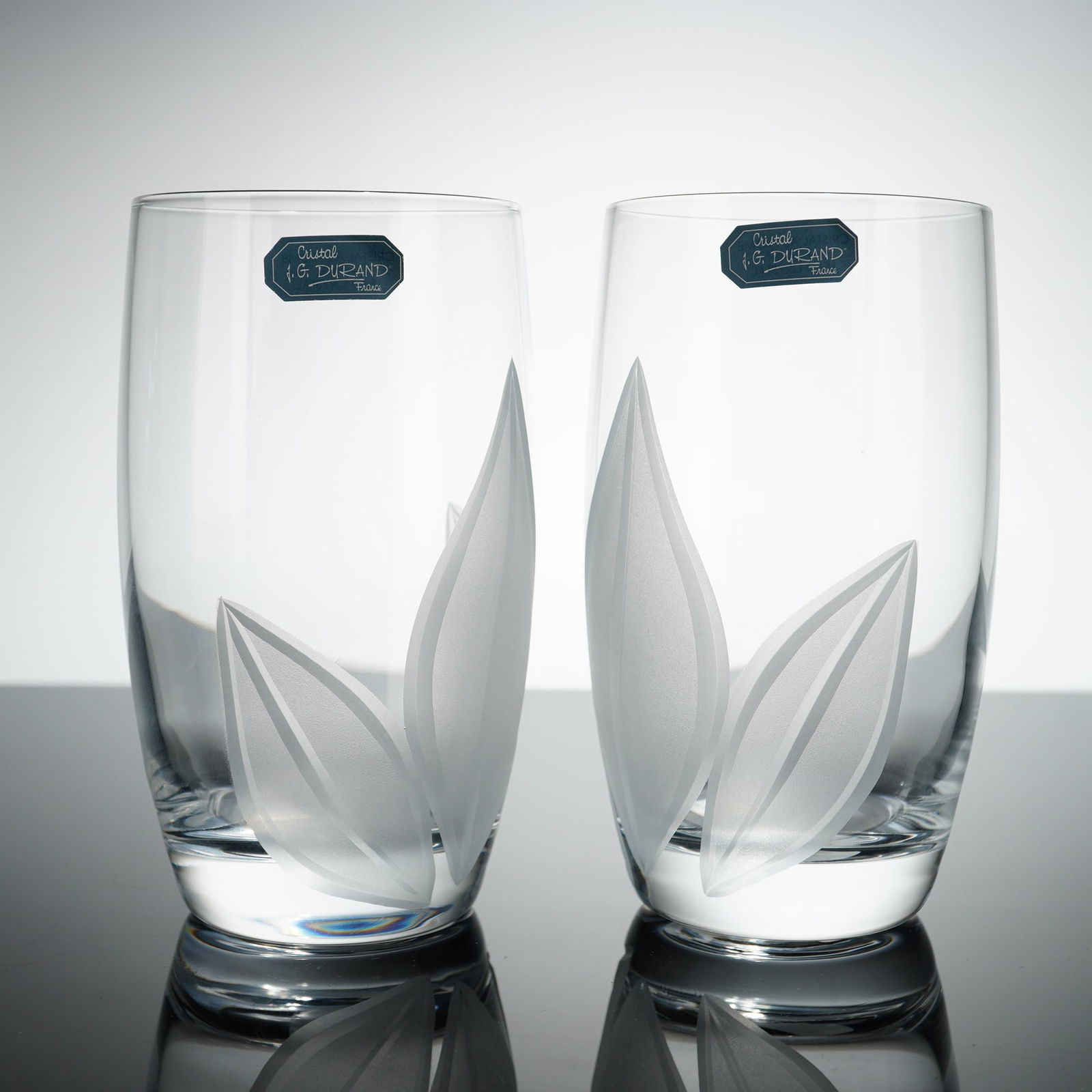 Pair of J.G. Durand France Crystal Highball Glasses, Val D'Isere: Each glass is constructed of 24 percent lead crystal and features a modern tapered form with a weighted base. The exterior is decorated with a frosted, acid-etched motif of stylized pointed leaves.