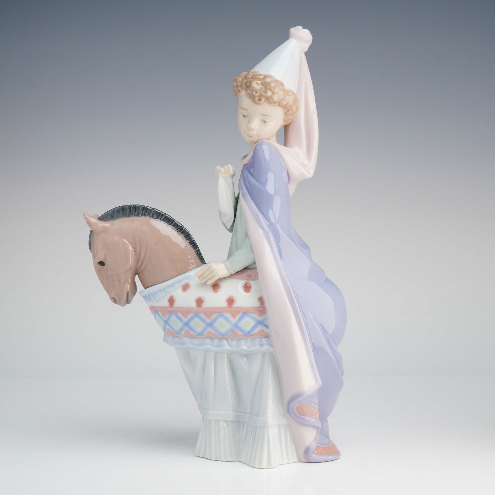 Lladro Porcelain Figurine Medieval Princess 6114: A single glazed porcelain figurine by Lladro, titled "Medieval Princess" (Model 6114). The piece depicts a young figure, dressed in a pastel-colored costume including a white conical cap and a long la