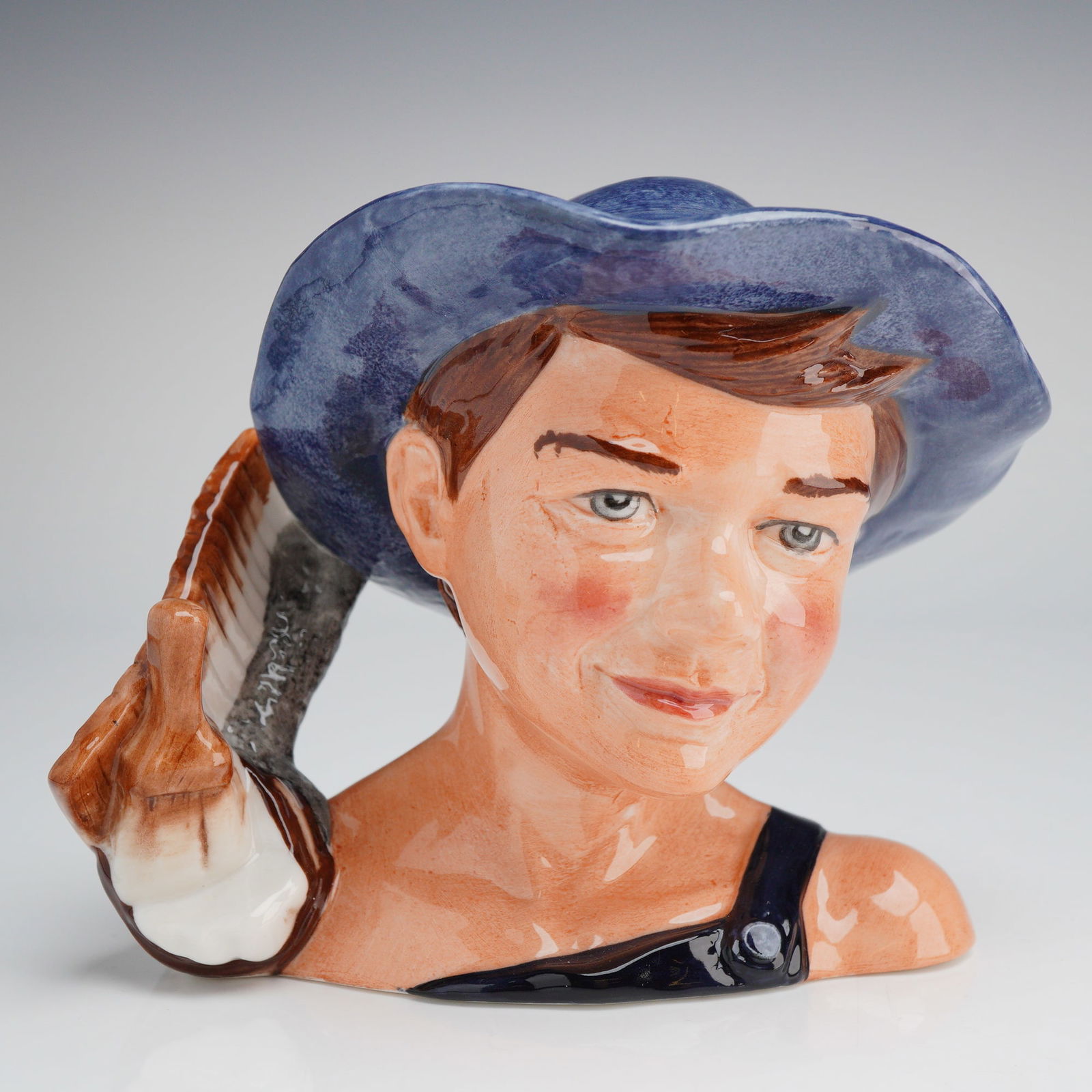 Royal Doulton Tom Sawyer D7187 Character Jug with Box: A Royal Doulton Character Jug, Tom Sawyer (D7187), modeled by Shane Ridge in 2002, depicting a young boy in a blue hat holding a brush handle, accompanied by its original box and paperwork. Dimensions