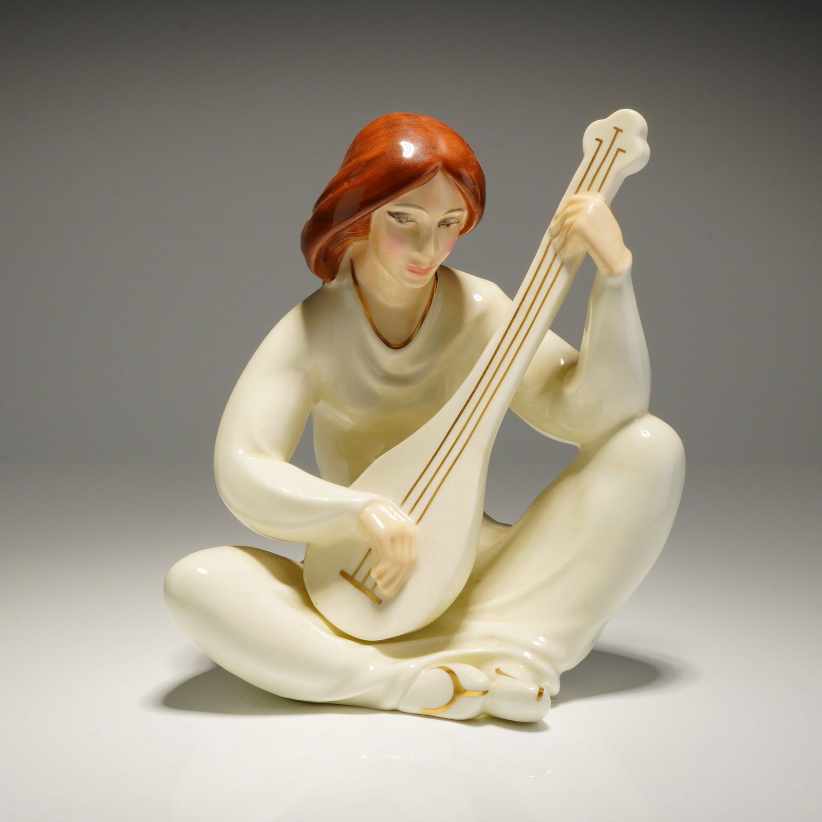 Royal Doulton Enchantment Collection Figurine Lyric HN2757: A Royal Doulton Figurine Lyric hn2757, modeled by Eric Griffiths for The Enchantment Collection in 1983, depicting a seated woman in cream bone china playing a lute with gold accents. Dimensions: 5.75