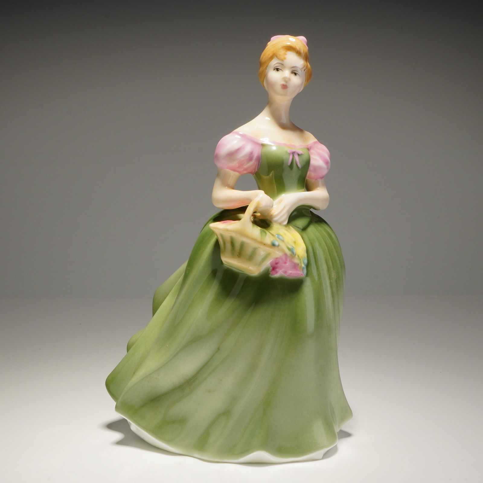 Royal Doulton Figurine Clarissa HN 2345: A single Royal Doulton porcelain figurine of a woman in a light green gown with pink sleeves, marked HN 2345 and COPR 1967. Dimensions: 4.75"L x 5.50"W x 7.50"H Weight: 14.00oz