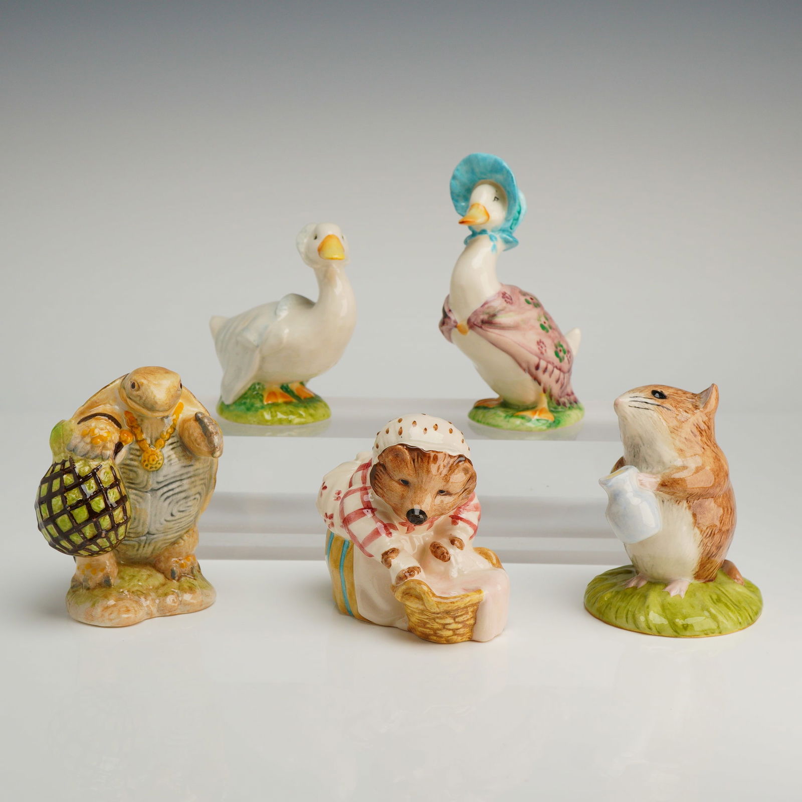 A Collection of Five Beswick Beatrix Potter Figurines: A collection of five ceramic Beswick Beatrix Potter figurines, including Mrs. Tiggy-Winkle Washing, Jemima Puddle-Duck, Timmy Willie Fetching Milk, Mr. Alderman Ptolemy, and Rebeccah Puddle-Duck, feat