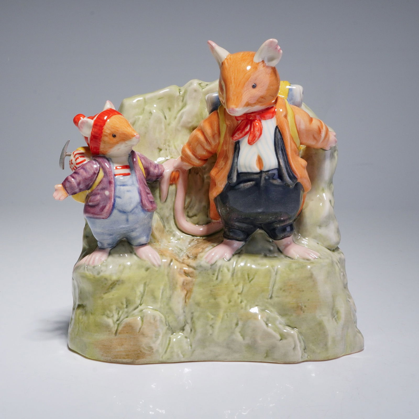Royal Doulton Brambly Hedge The High Hills Figurine, On the Ledge DBH57: This hand-made and hand-decorated piece is based on the Brambly Hedge series by Jill Barklem. The figurine depicts two anthropomorphic mice in mountaineering attire standing on a textured, green-toned