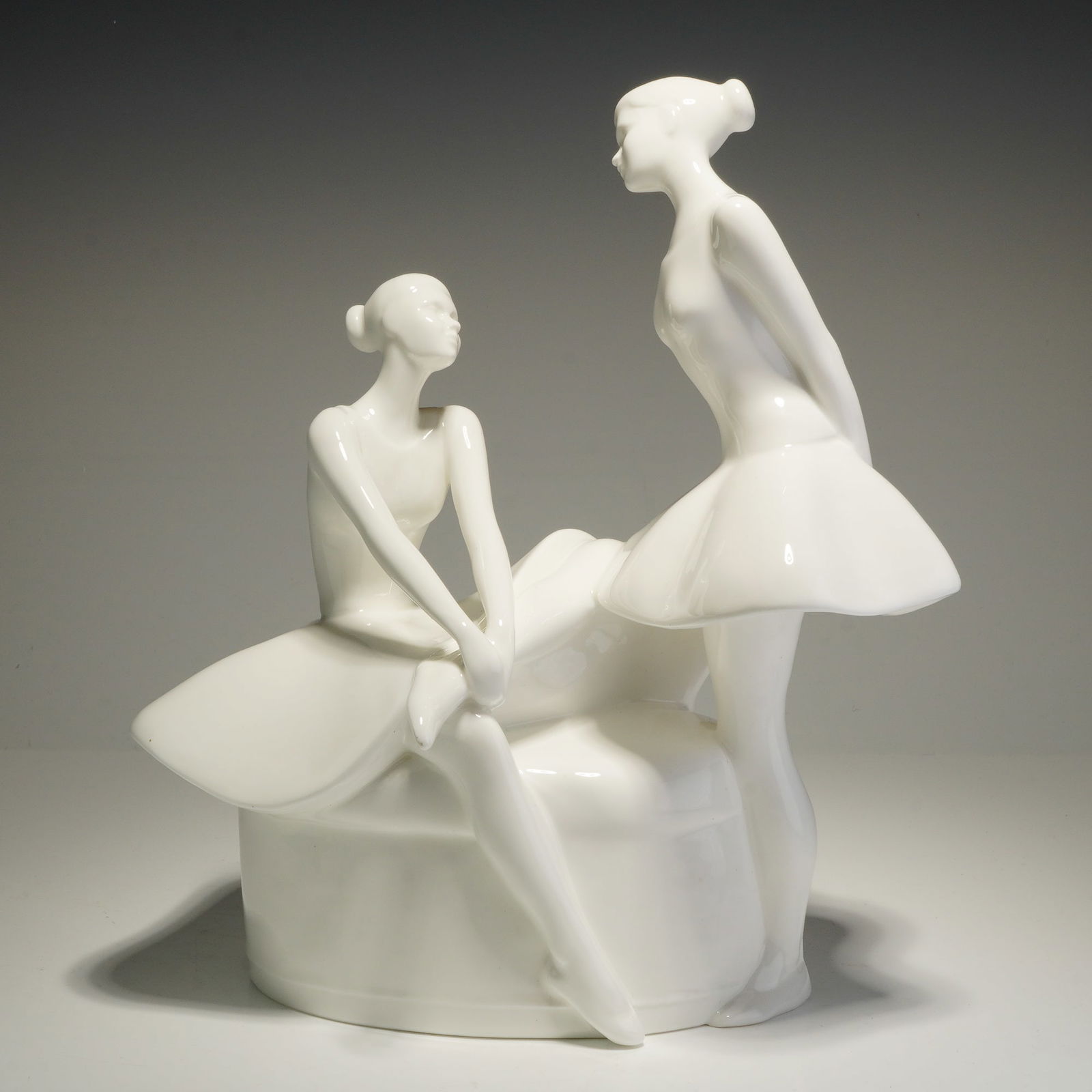 Royal Doulton Images Series Figurine, The Performance HN3827: This Royal Doulton bone china figurine, titled The Performance (HN 3827) from the Images series, depicts two ballerinas in a minimalist style. The group is rendered in a high-gloss white glaze. One fi