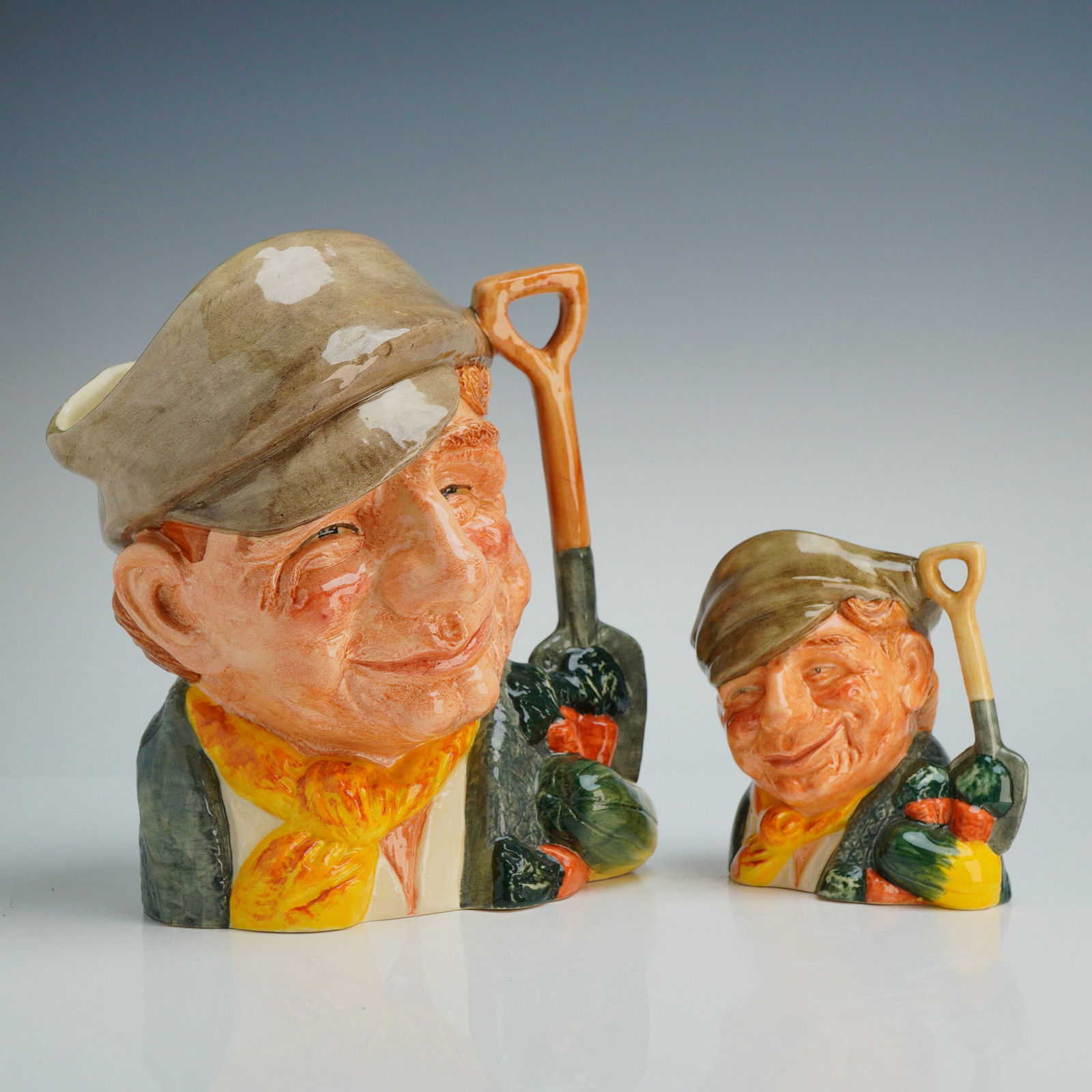 2pc Royal Doulton Character Jugs, The Gardener D 6630 & D 6634: A collection of two Royal Doulton ceramic character jugs titled The Gardener, including the large model D 6630 and the small model D 6634. The design depicts a man in a flat cap and neckerchief with a