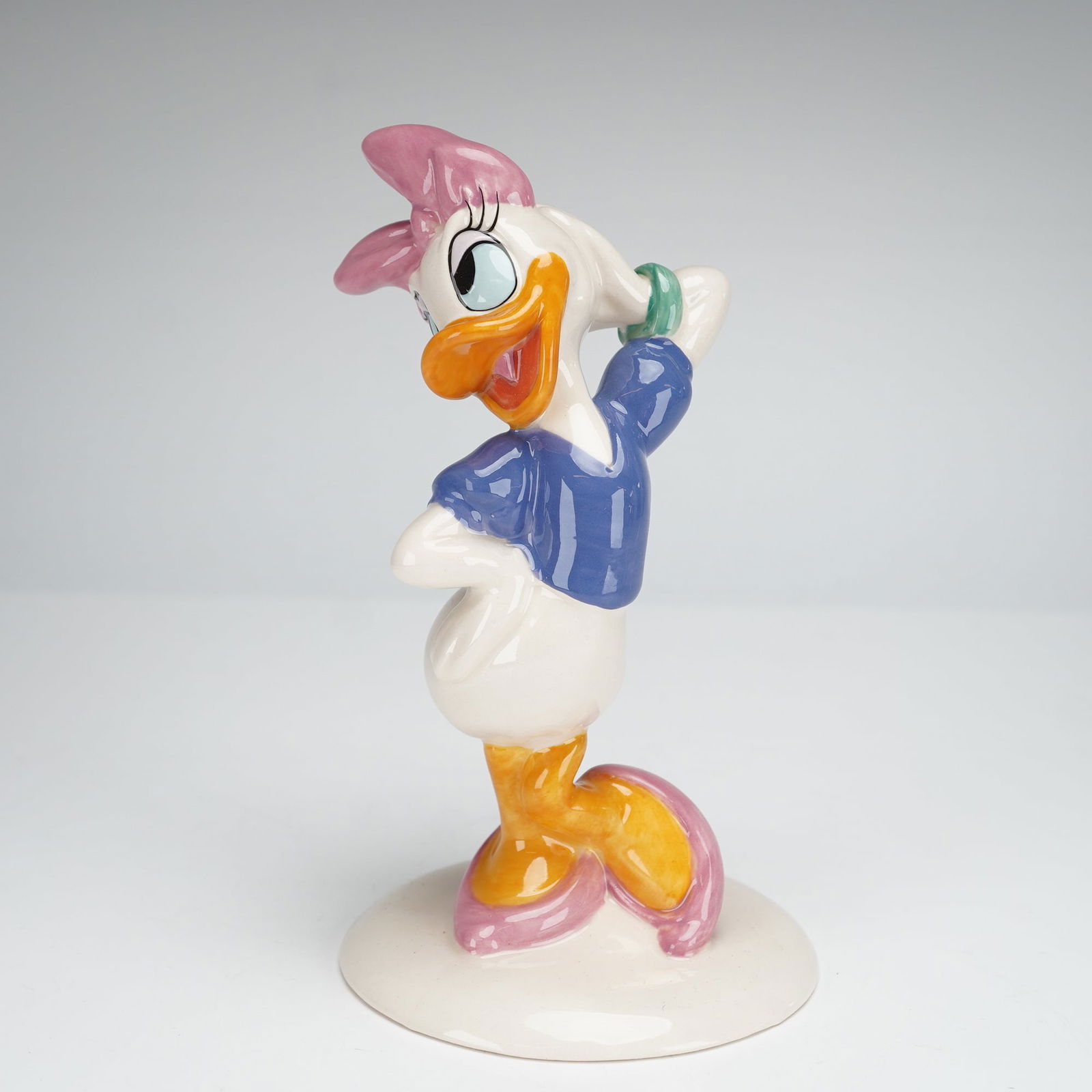 Royal Doulton Mickey Mouse Collection Figurine, Daisy Duck MM4: A glazed and hand-decorated ceramic figurine of the Disney character Daisy Duck, produced by Royal Doulton as part of The Mickey Mouse Collection celebrating the 70th Anniversary of Mickey Mouse (1928