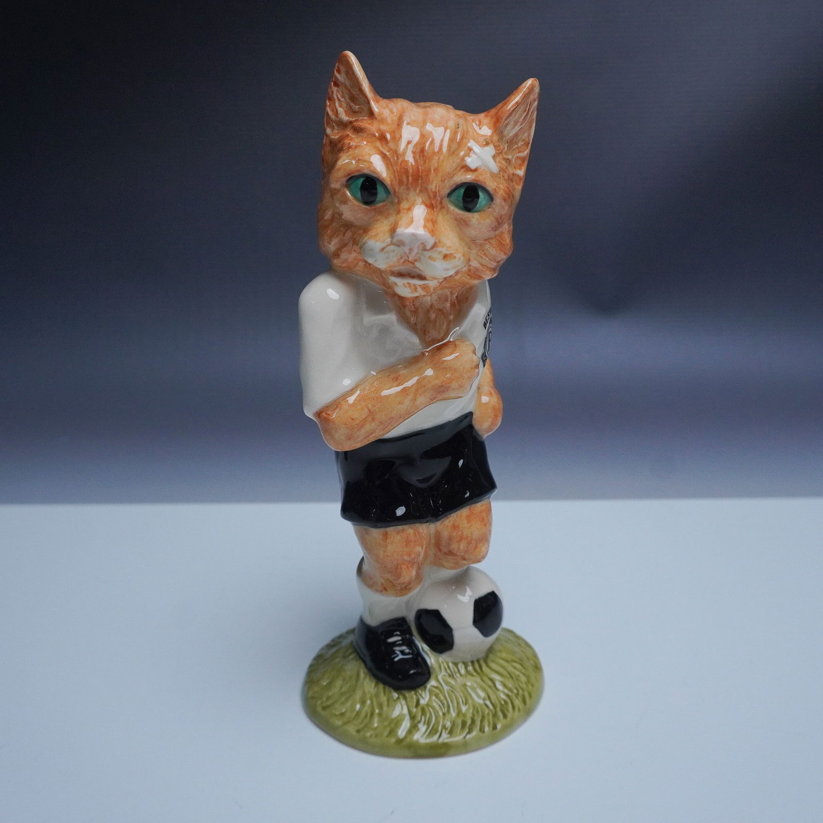 Beswick Footballing Felines Collection Dribble Figurine: This whimsical figurine from the John Beswick Footballing Felines Collection, titled Dribble FF4, features a hand-painted ceramic cat poised with a soccer ball, dressed in a black and white football u