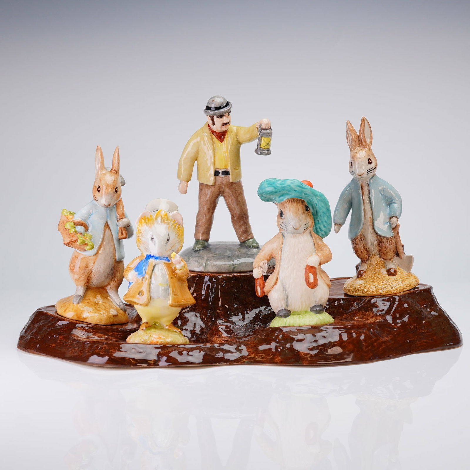 6pc Beswick Beatrix Potter Peter Rabbit Gardening Set with Base: Beswick glazed ceramic figurines and one separate high-gloss brown ceramic display base, depicts characters from the Beatrix Potter stories. The 5 figurines include Peter Rabbit Gardening, Peter Rabbi