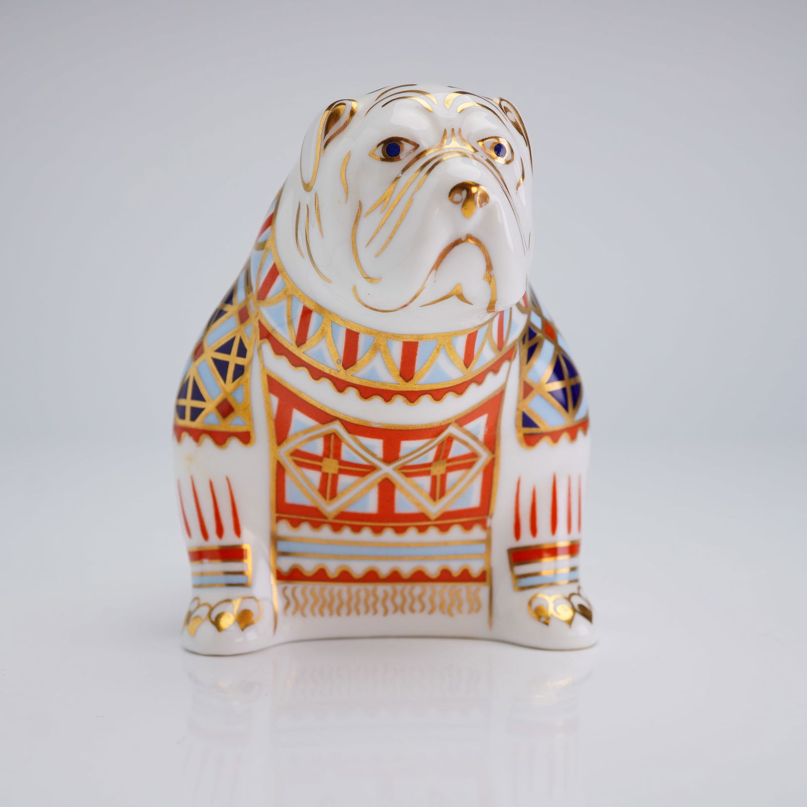Royal Crown Derby Bulldog Paperweight: Royal Crown Derby Bulldog paperweight. This figure is crafted from English bone china and depicts a seated bulldog decorated in a traditional Imari-style palette of cobalt blue, iron red, and light bl