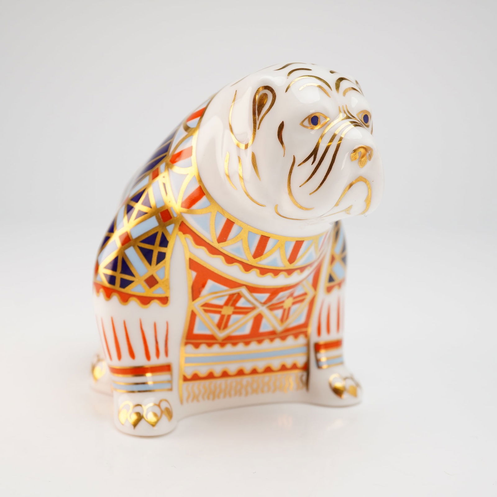 Royal Crown Derby Old Imari Bulldog Paperweight with Box: A Royal Crown Derby fine bone china paperweight in the form of a seated bulldog. The figurine features a stylized Imari-patterned body with cobalt blue, iron red, and light blue geometric and floral m